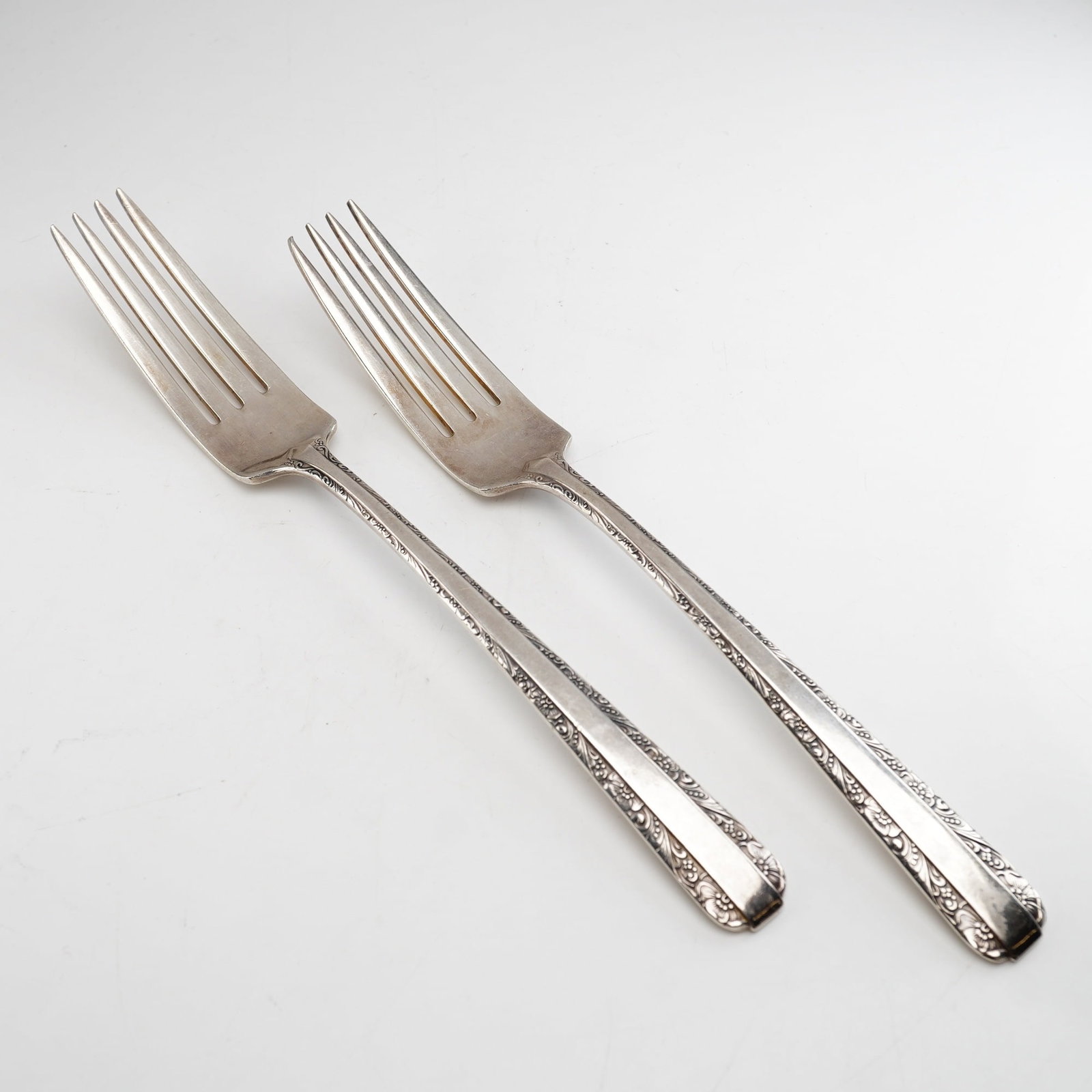 2pc Towle Candlelight Sterling Silver Forks: Two solid sterling silver forks in the Candlelight pattern, produced by Towle Silversmiths. The pattern, first introduced in 1934, features a slender handle decorated with delicate floral and foliate 