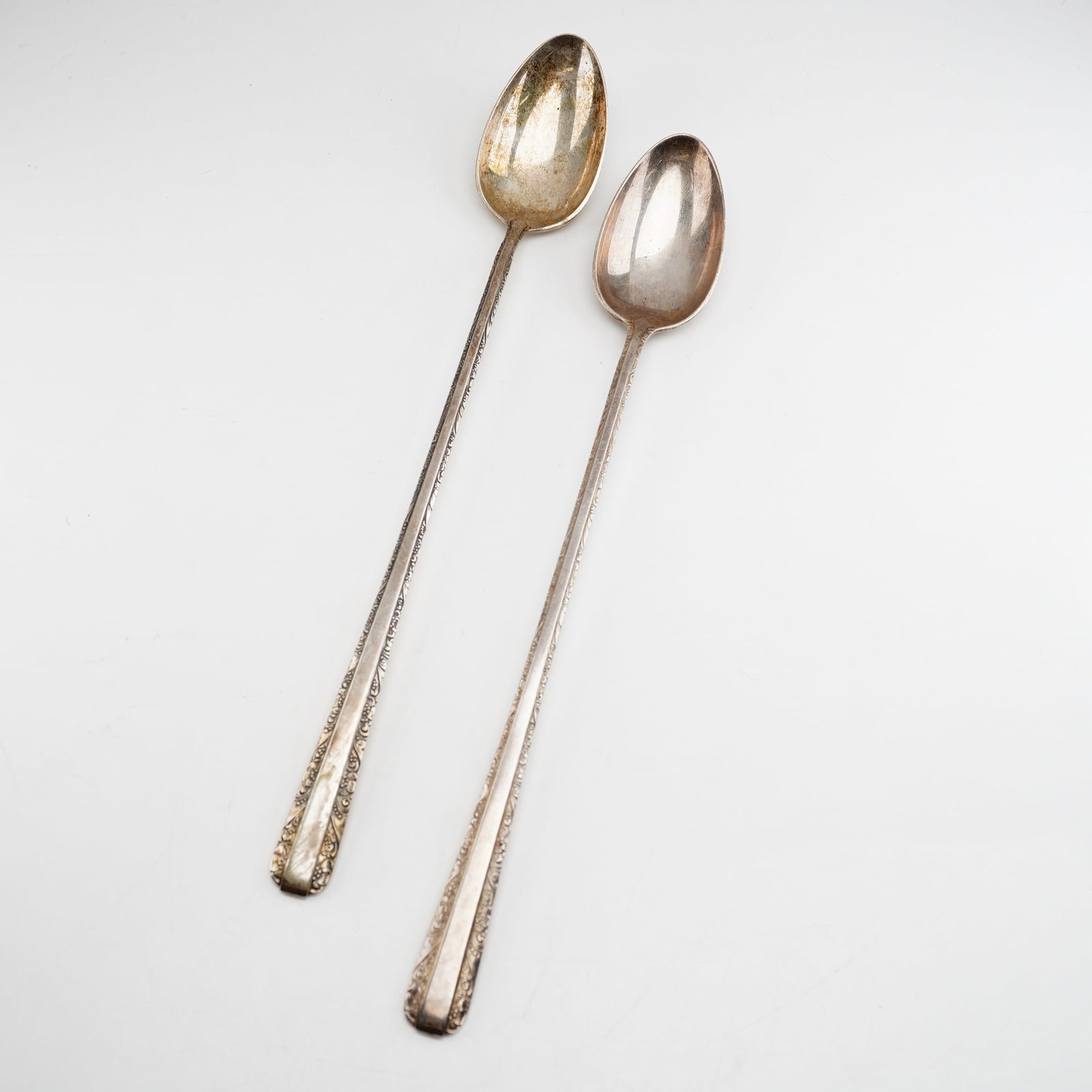 2pc Towle Candlelight Sterling Silver Iced Tea Spoons: Two long-handled iced tea spoons produced in the Candlelight pattern by Towle Silversmiths. The design features ornate floral and scroll borders along the edges of the tapered handles. Each piece is m