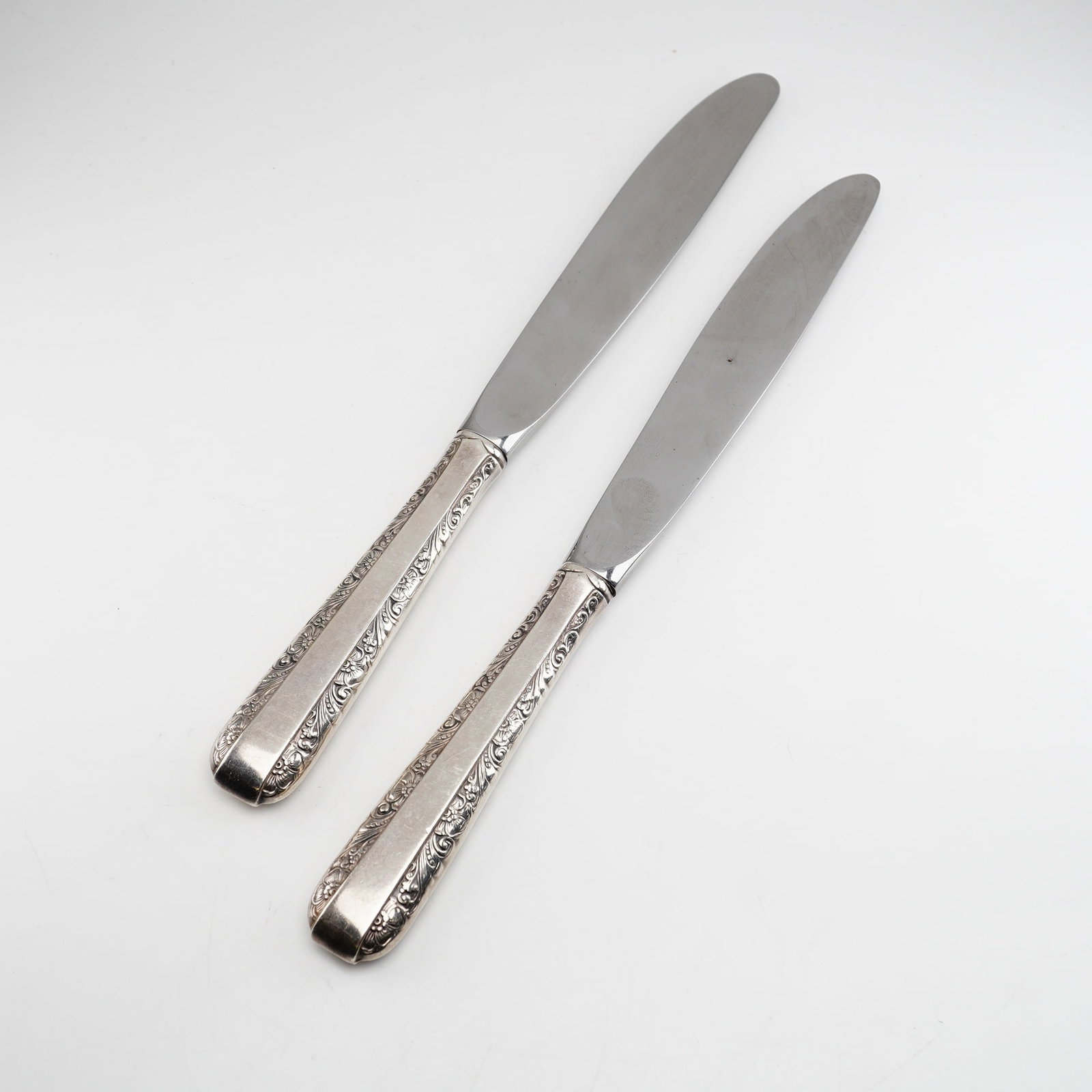 2pc Towle Candlelight Sterling Silver Knives with Stainless Steel Blades: Two silver-handled knives in the Candlelight pattern by Towle, a design first introduced in 1934. The handles are constructed from weighted sterling silver and feature an ornate border of scrolled fol