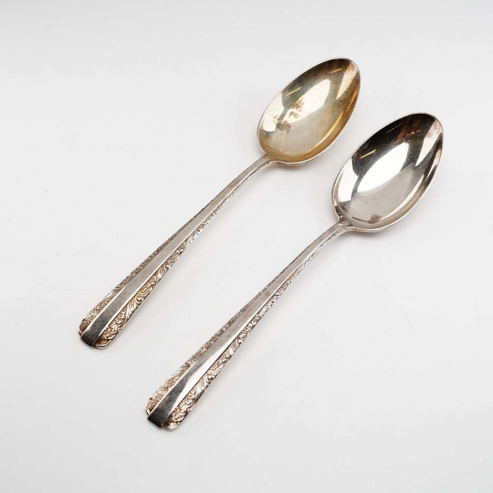 2pc Towle Candlelight Sterling Silver Spoons: Two solid sterling silver spoons in the Candlelight pattern manufactured by Towle Silversmiths. Introduced in 1934, the Candlelight pattern is characterized by a sleek, unornamented central panel on t