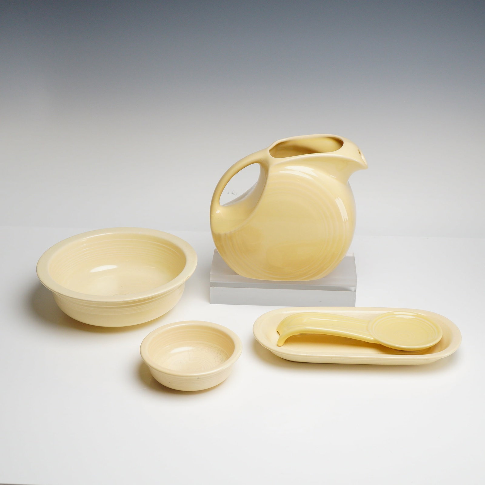 Five-Piece Homer Laughlin Fiesta Tableware Collection: Crafted from glazed earthenware, specifically semi-vitreous china, the set features the iconic Art Deco styling and concentric ring pattern characteristic of the Fiesta line. Each piece is finished in