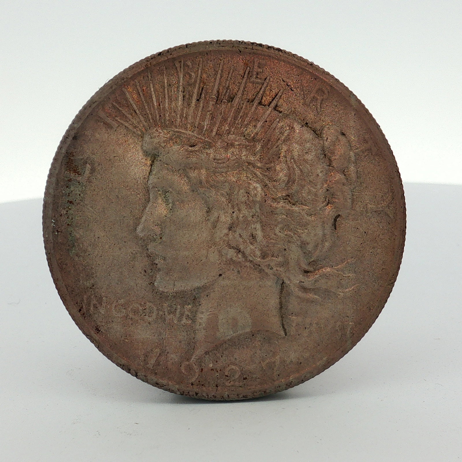 1927 US Peace Silver Dollar: This US Peace silver dollar is dated 1927. It is composed of a 90 percent silver and 10 percent copper alloy. The coin features the standard obverse and reverse designs of the series. No mint mark is 