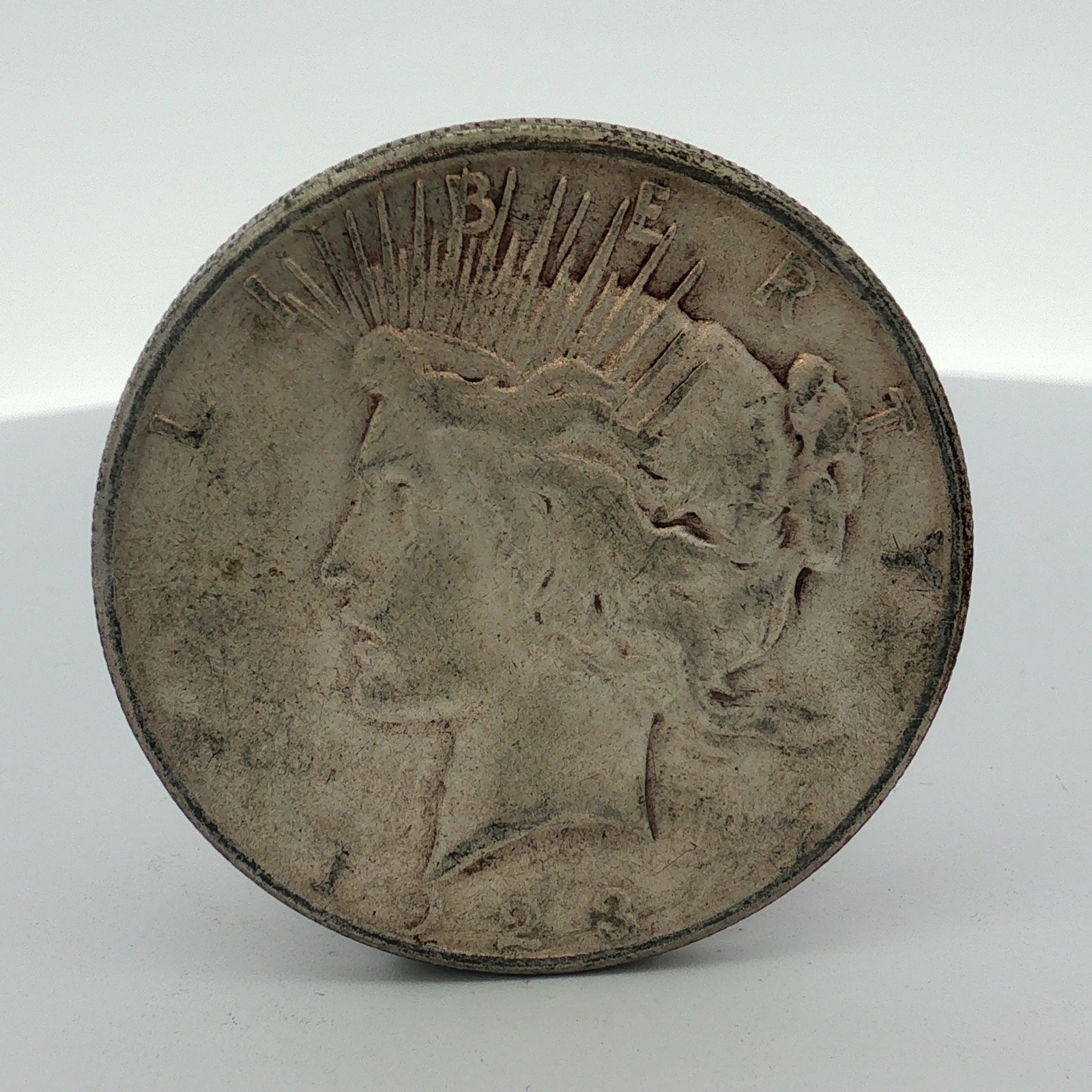 1928-S US Peace Silver Dollar: This US 1928-S Peace silver dollar is a struck coin composed of 90% silver (.900 fineness) and 10% copper. The coin features the Peace dollar obverse and reverse designs. It was struck at the San