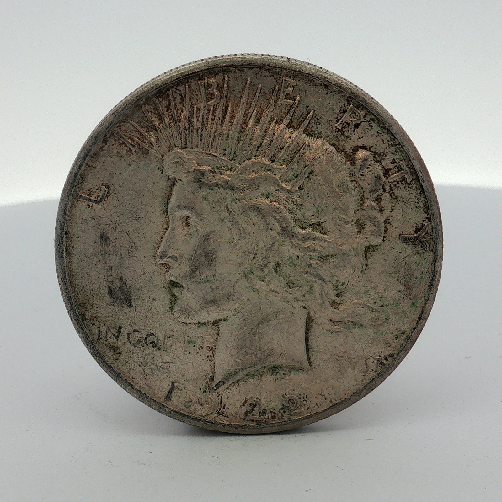 US 1922-S Peace Silver Dollar: This US Peace silver dollar was struck at the San Francisco Mint in 1922. The coin is composed of 90 percent silver and 10 percent copper. It features the standard Peace dollar obverse and reverse des