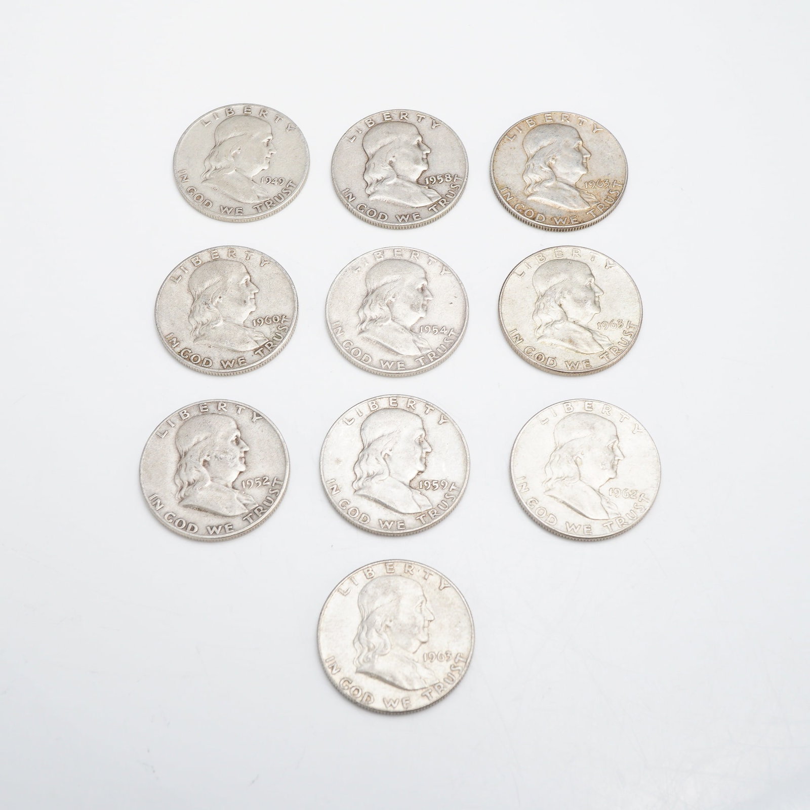 A Collection of US Franklin Half Dollars, $5.00 Face Value: A collection of US Franklin Half Dollars with a total $5.00 face value. These coins are struck in 90% silver (0.900 fine) with a 10% copper alloy. The assortment includes various dates ranging from 19