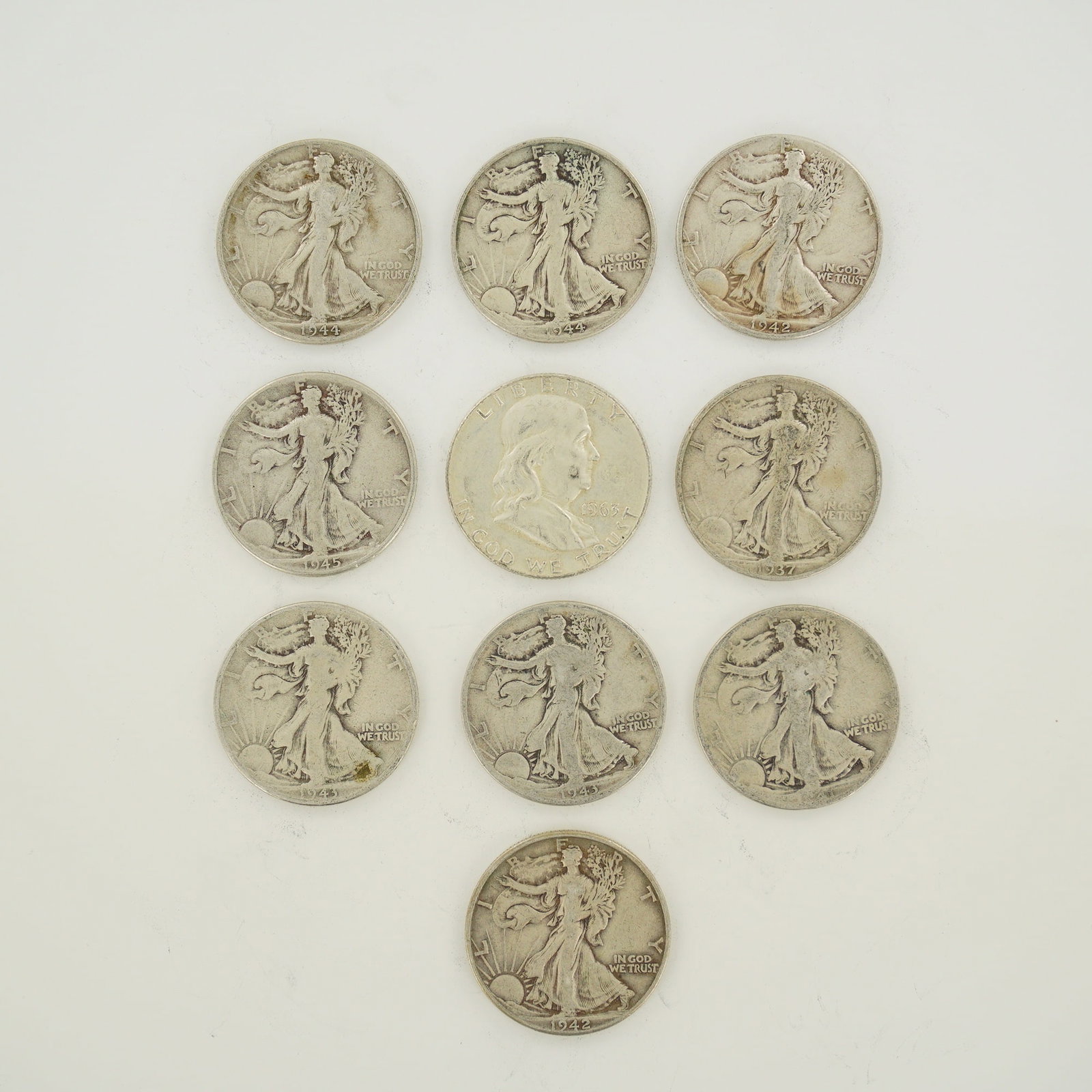 A Collection of US 90% Silver Walking Liberty and Franklin Half Dollars: A collection of US 90% silver half dollars featuring the Walking Liberty and Franklin designs. This mixed date bag of coins includes Walking Liberty half dollars with dates including 1937, 1942, 1943,