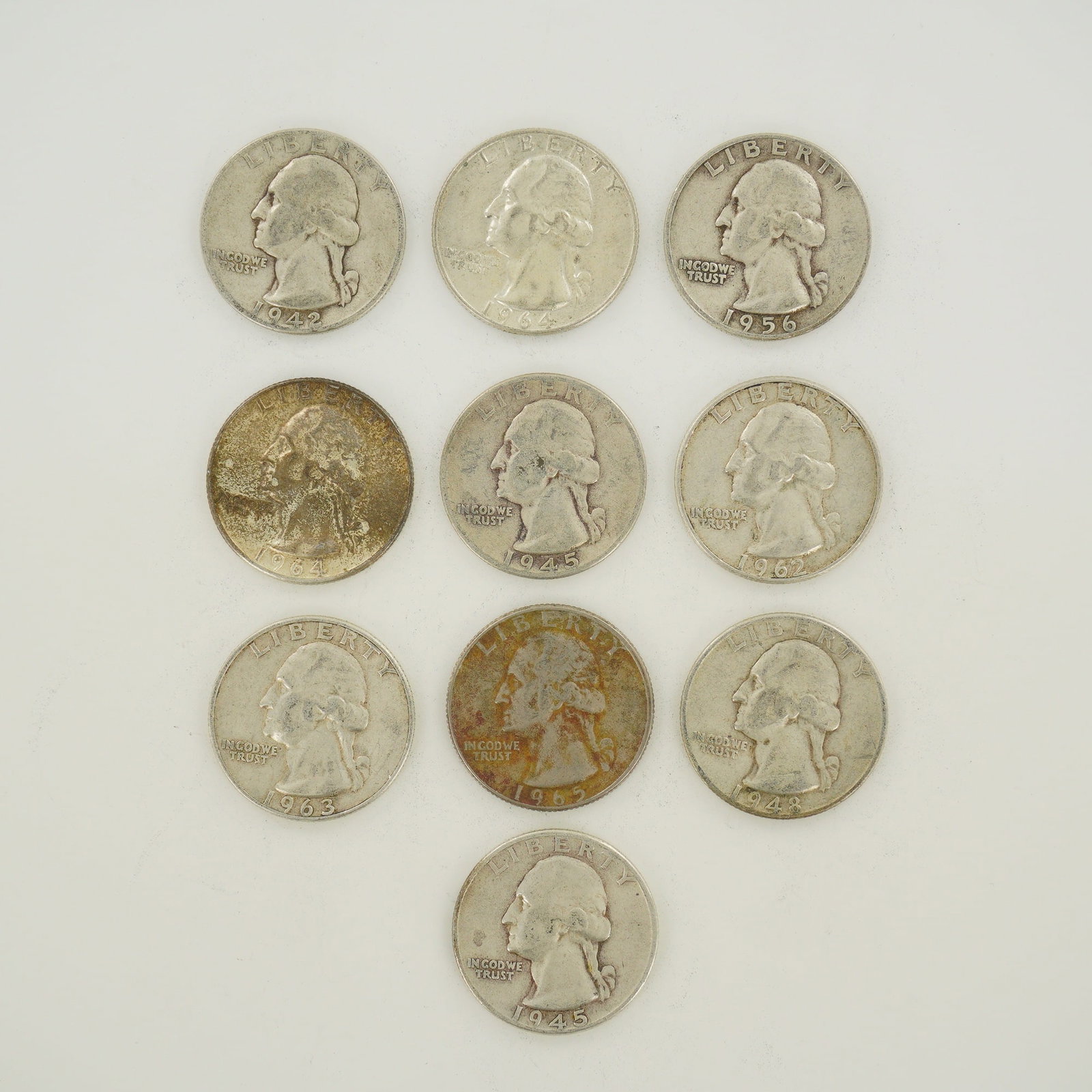 10pc Pre-1964 U.S. 90% Silver Washington Quarters: A collection of US Washington quarters featuring 90% silver examples and a copper-nickel clad example. The silver coins include dates 1942, 1945-D, 1945-S, 1948-D, 1956-D, 1962-D, 1963-D, and 1964. Th