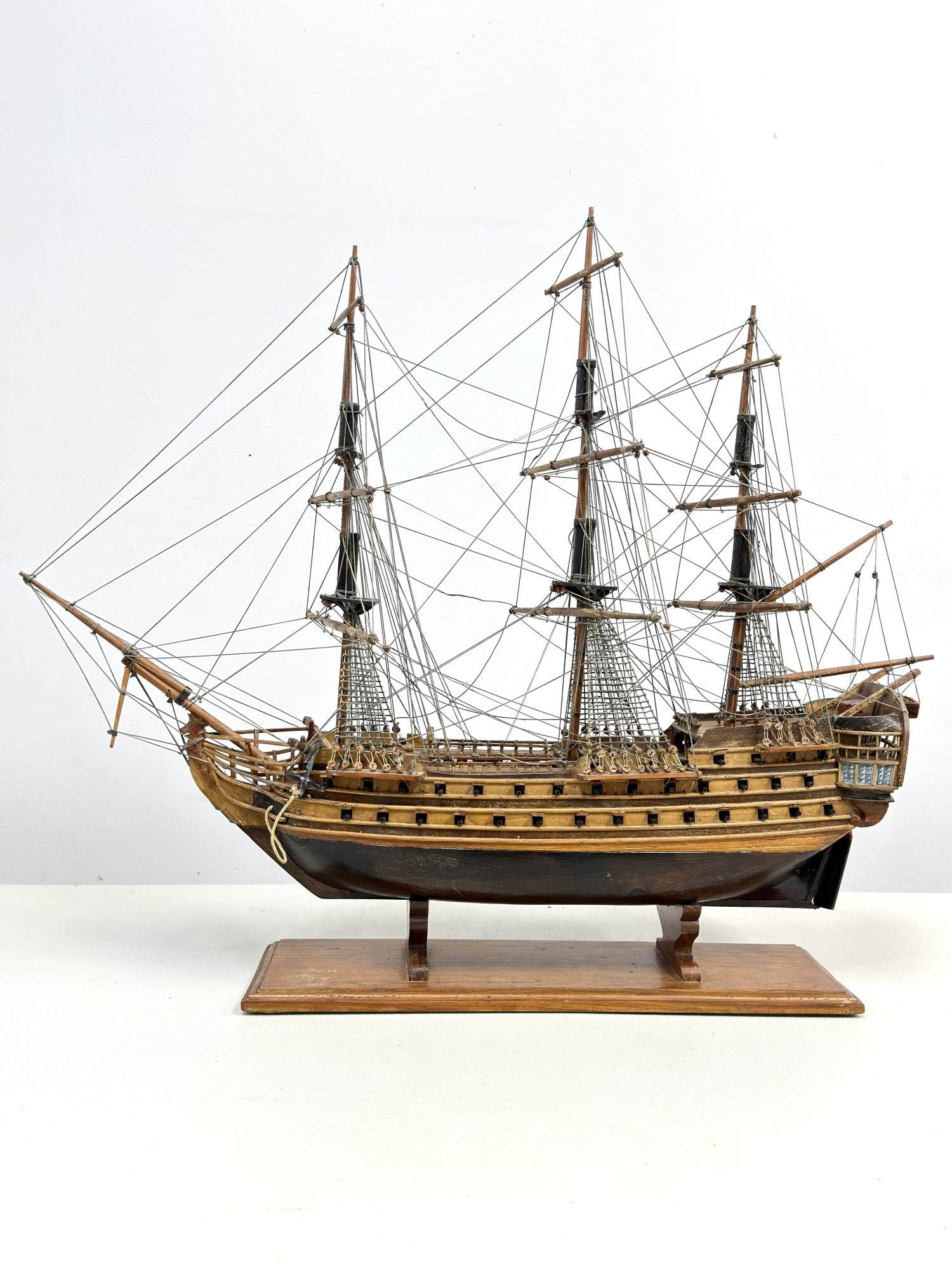 Historic Three Mast Handcrafted Wooden Sailing Ship Model Affixed to Base: This historic three mast handcrafted wooden sailing ship model is designed in the style of a 17th or 18th-century man-of-war, closely resembling the decorative models produced by Old Modern Handicraft