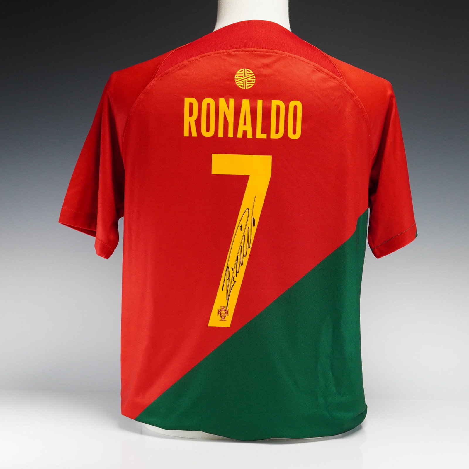 Cristiano Ronaldo Autographed Portugal National Team 2022-23 Nike Replica Home Jersey with The: This is an official Nike replica home jersey for the Portugal national team, representing the 2022-23 season and the 2022 FIFA World Cup. The jersey features a distinctive diagonal split design in