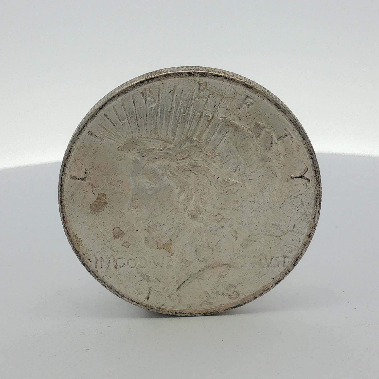 1923 US Peace Silver Dollar: This 1923 US Peace silver dollar was struck at the Philadelphia Mint. The coin is composed of 0.900 fine silver and 0.100 copper. The obverse features the standard Liberty head design with the