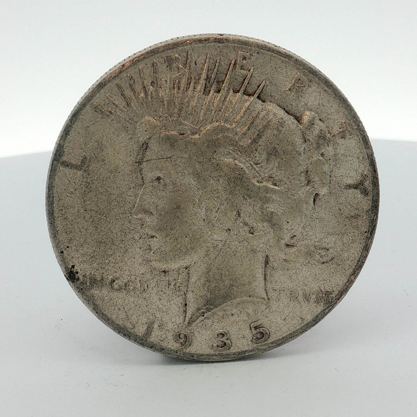 1935-S US Peace Silver Dollar: A United States Peace silver dollar struck at the San Francisco Mint in 1935. The obverse features the Peace dollar design with the date 1935 and the motto IN GOD WE TRVST. The reverse displays the S