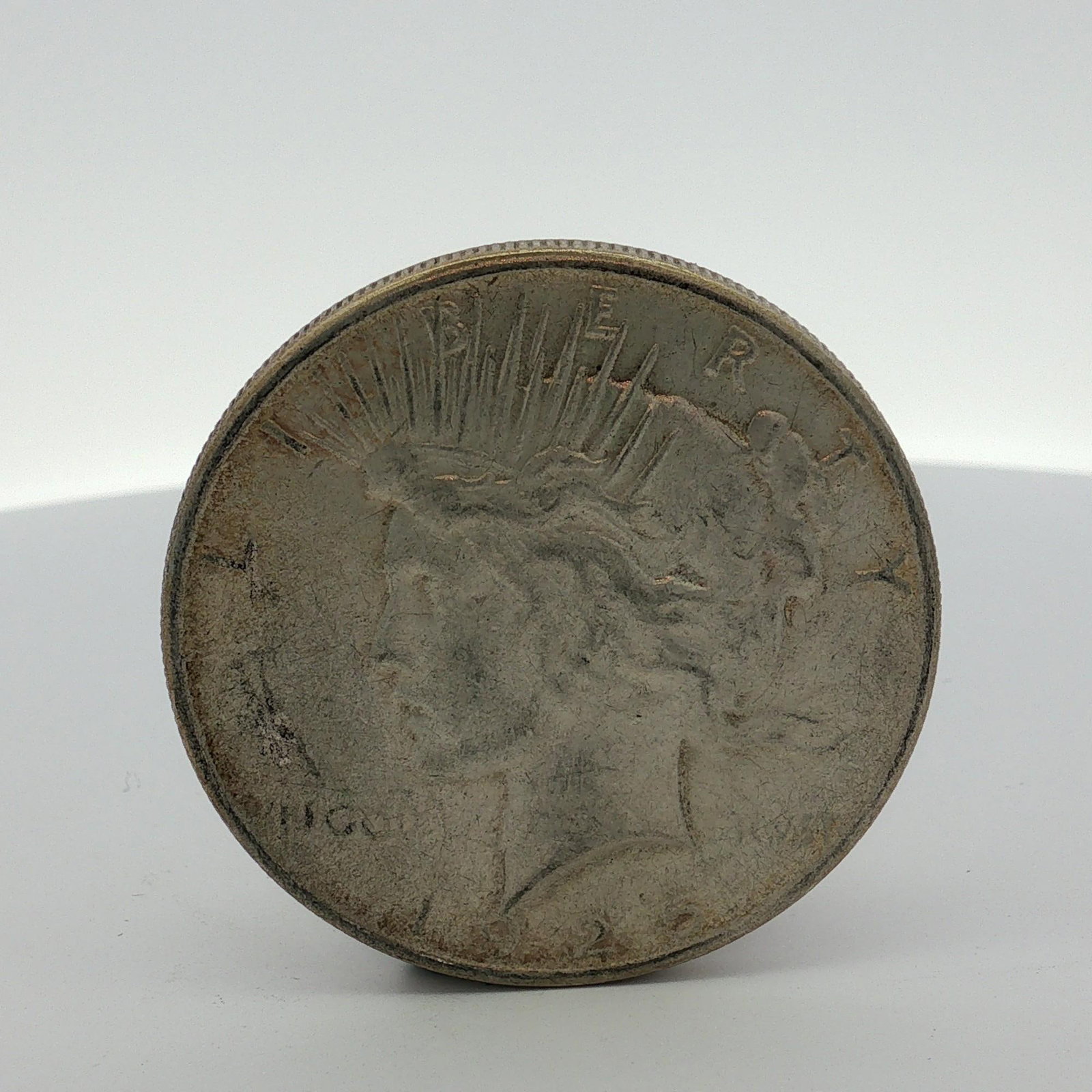 US 1922 Peace Silver Dollar: This US silver one dollar coin, known as a Peace dollar, is dated 1922 and struck in 90% silver. The obverse features the Peace dollar profile with the legends LIBERTY and IN GOD WE TRVST. The
