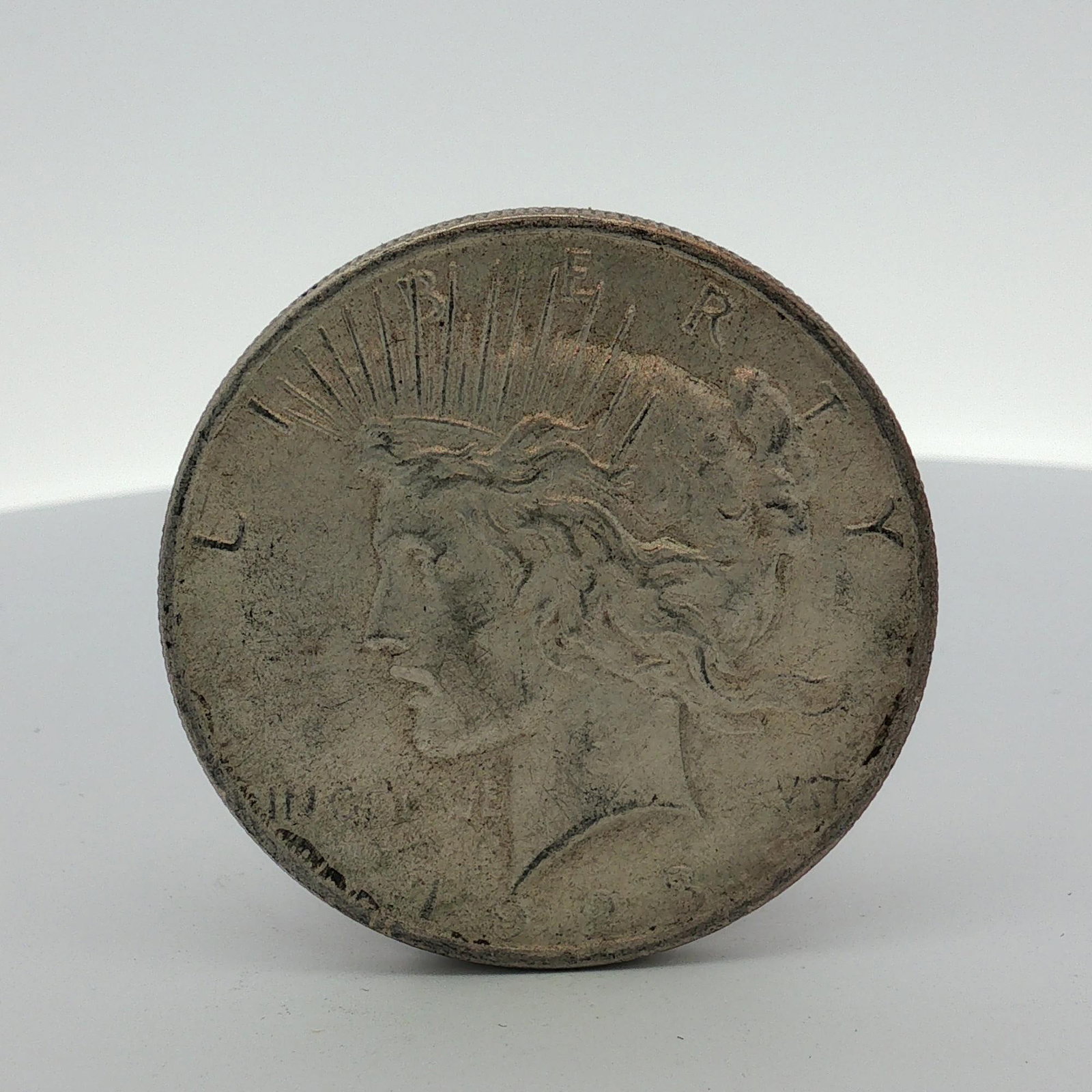 US Silver Peace Dollar: This struck US silver Peace Dollar is composed of .900 fine silver. The coin features the Peace Dollar obverse and Peace Dollar reverse designs. The obverse date is partially legible as 192[?]. No
