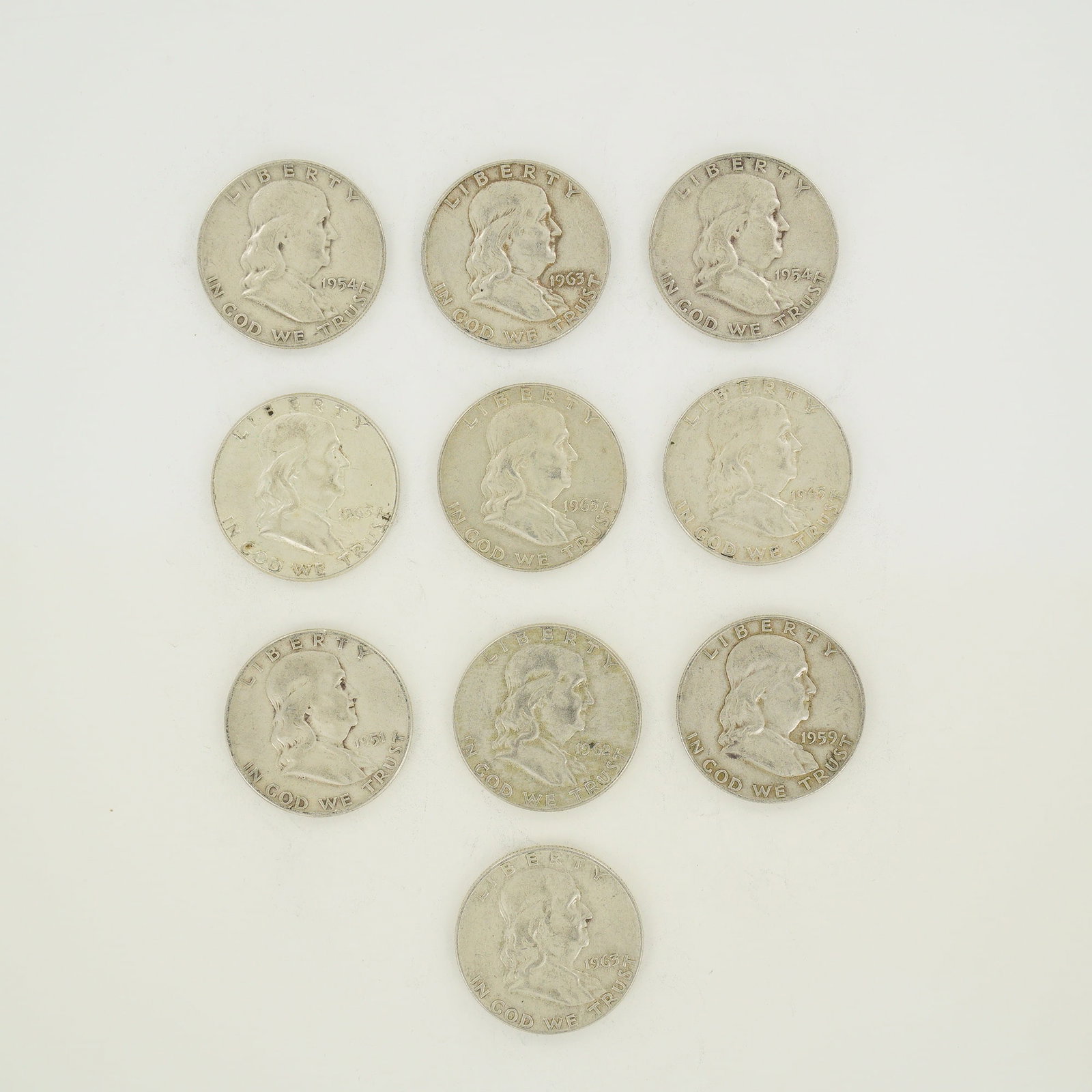 A Collection of 10 US Ben Franklin Half Dollars 1951-1963: A collection of 10 US Ben Franklin half dollars dated between 1951 and 1963. These coins are struck in 90% silver and 10% copper. The group includes the following date and mint mark combinations: 1951