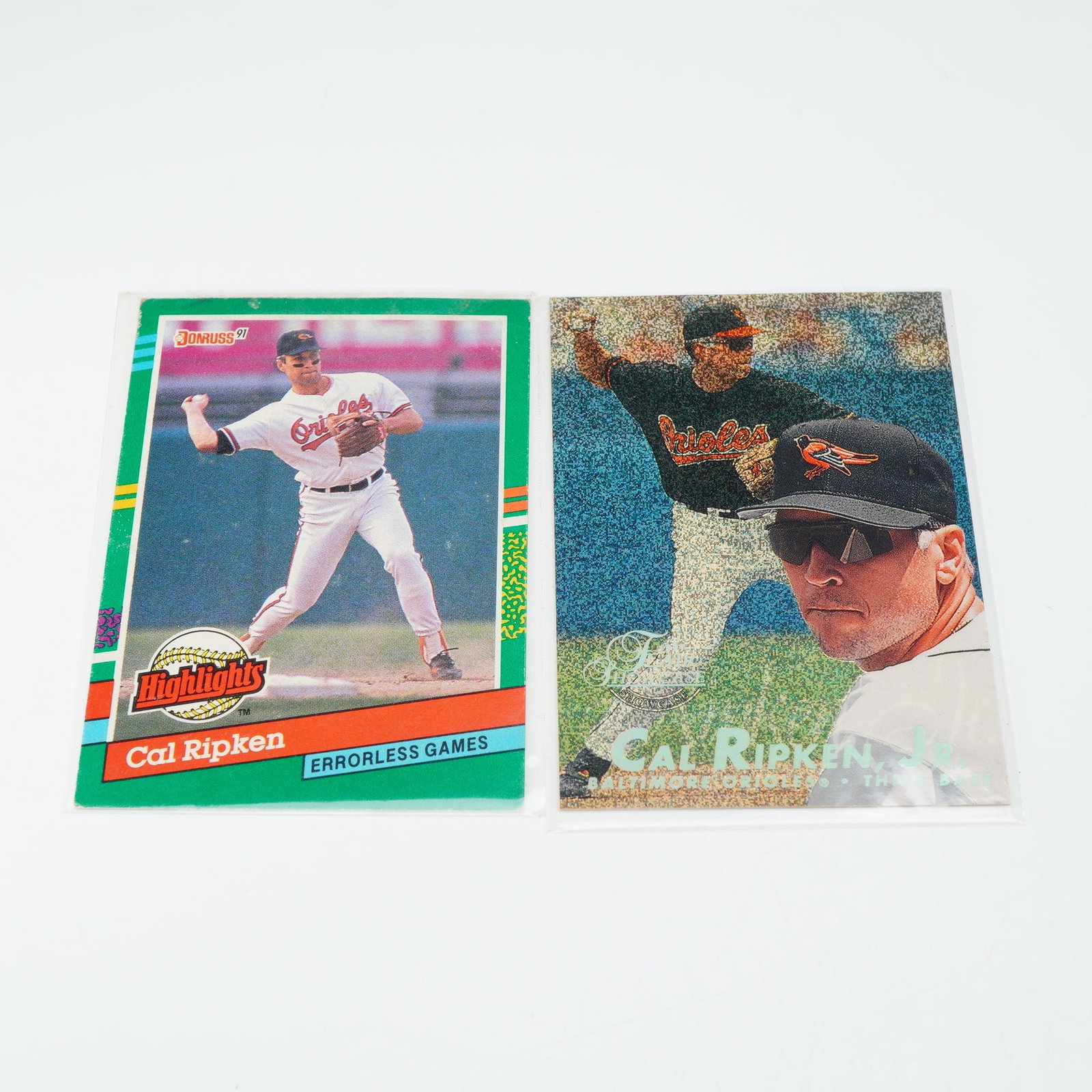 2pc Cal Ripken Jr. Collectible Baseball Cards Including 1991 Donruss Highlights and 1997 Flair: This lot consists of two collectible baseball cards featuring Baltimore Orioles Hall of Fame infielder Cal Ripken Jr. The first card is a 1991 Donruss Highlights #BC-17, commemorating his record for