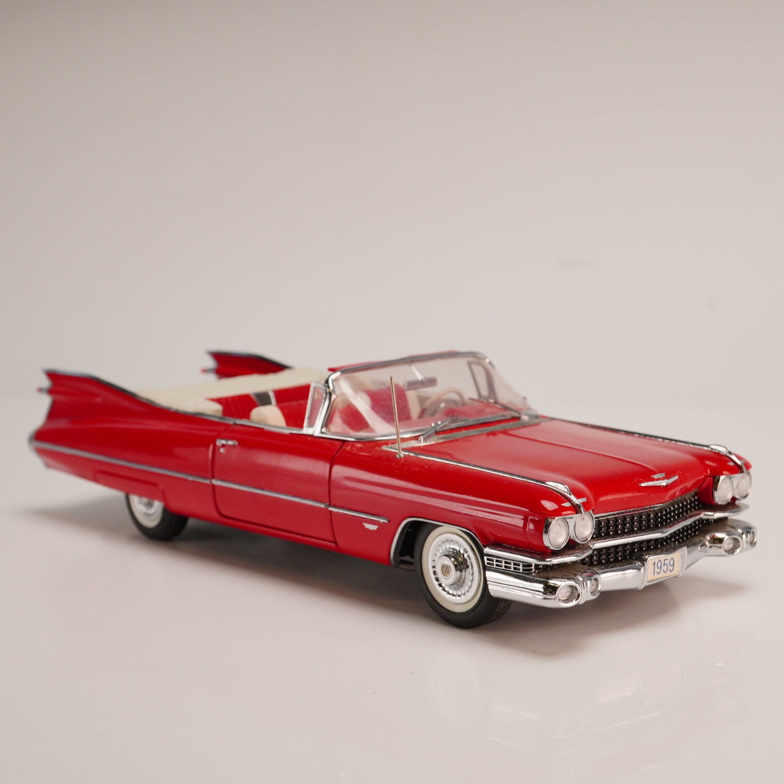 The Danbury Mint Classic Model Car, 1959 Cadillac Series 62: This die-cast metal replica of a 1959 Cadillac Series 62 Convertible is part of the Danbury Mint Classic Cars Collection. Produced at 1:24 scale, the model is finished in vibrant red with a
