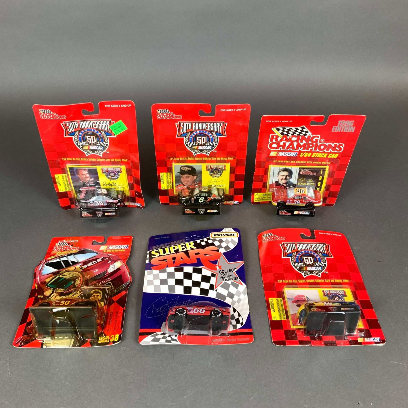 A Collection of Six NASCAR 1:64 Scale Die-Cast Model Cars Including Racing Champions and Matchbox: A collection of six NASCAR 1:64 scale die-cast model cars, primarily manufactured by Racing Champions and Matchbox. The group contains multiple releases from the late 1990s, including several