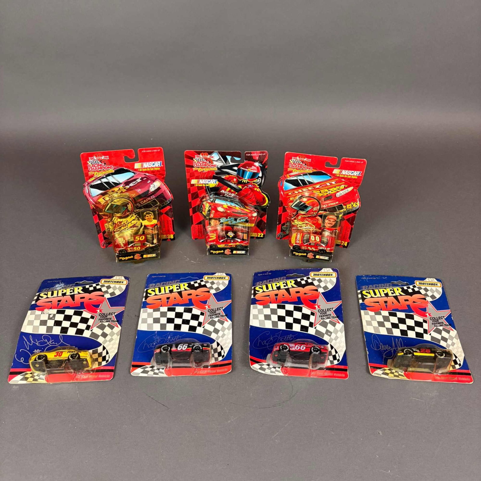 7pc Racing Champions NASCAR and Matchbox Racing Super Stars Die Cast Metal Cars: Collection of die-cast racing vehicles including three Racing Champions NASCAR models featuring Bill Elliott #94, Larry Pearson #00, and Mark Green #50. Also included are four Matchbox Racing Super