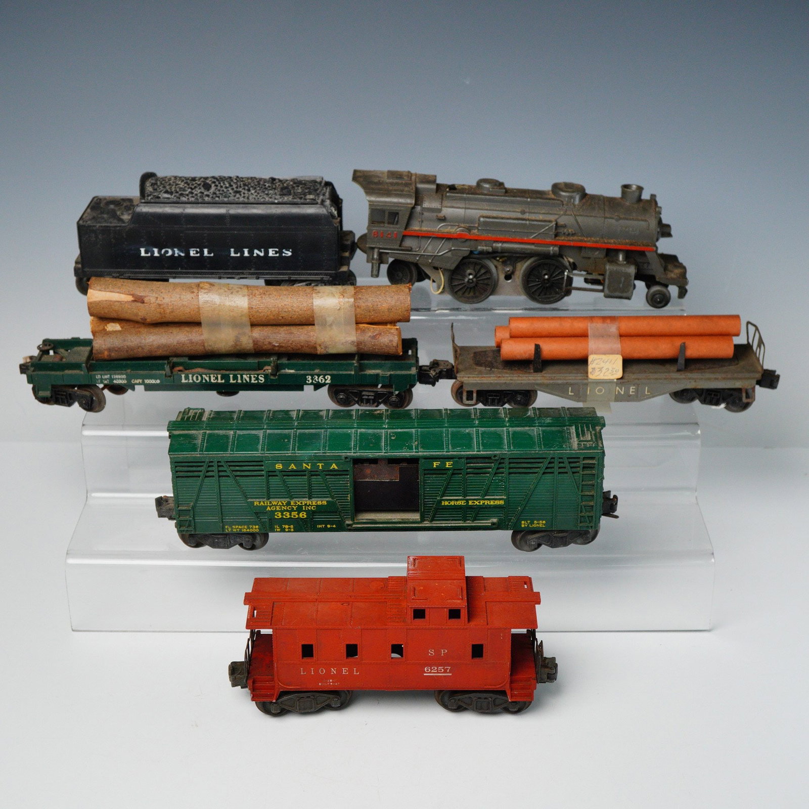 6pc Lionel Model Railroad Components MPC and Postwar Era: A collection of six individual Lionel model railroad components, constructed primarily of painted die-cast and sheet metal. The collection includes a dark gray steam-type locomotive, a black tender ma