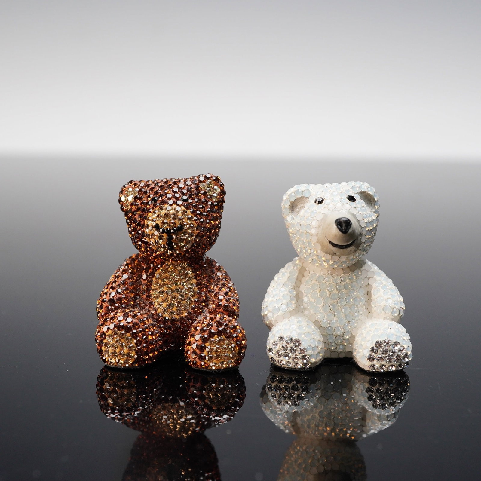 2pc Crystal-Encrusted Teddy Bear Figurines: A charming pair of sparkling teddy bear figurines, each fully encrusted with shimmering crystals. One bear features a warm amber-brown tone, while the other is finished in icy white with a cheerful