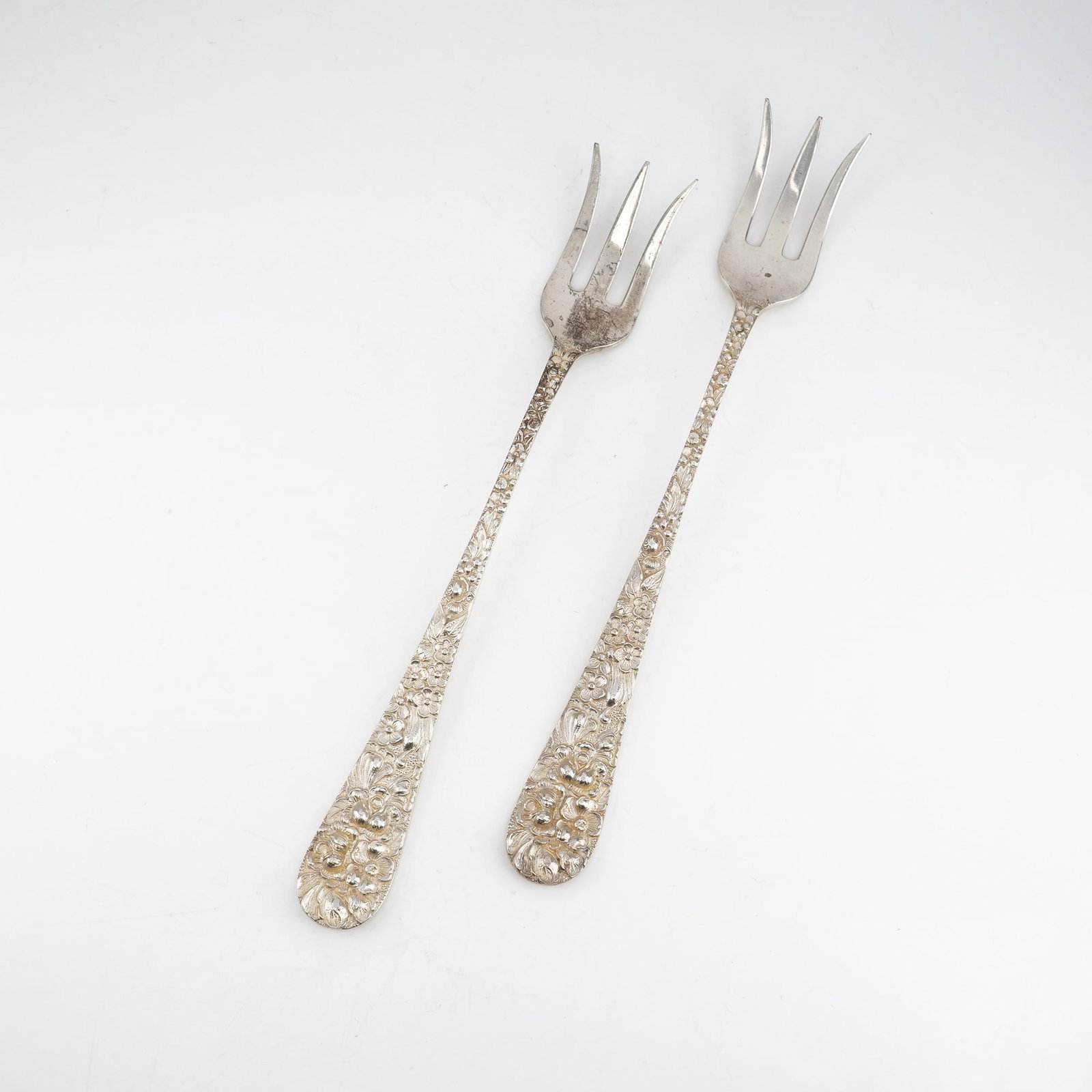 2pc Kirk Stieff Sterling Silver Cocktail Forks, Stieff Rose: Pair of finely crafted cocktail forks in the classic Stieff Rose motif, introduced in 1892. Each piece features ornate sterling silver handles with detailed floral repousse decoration executed in trad