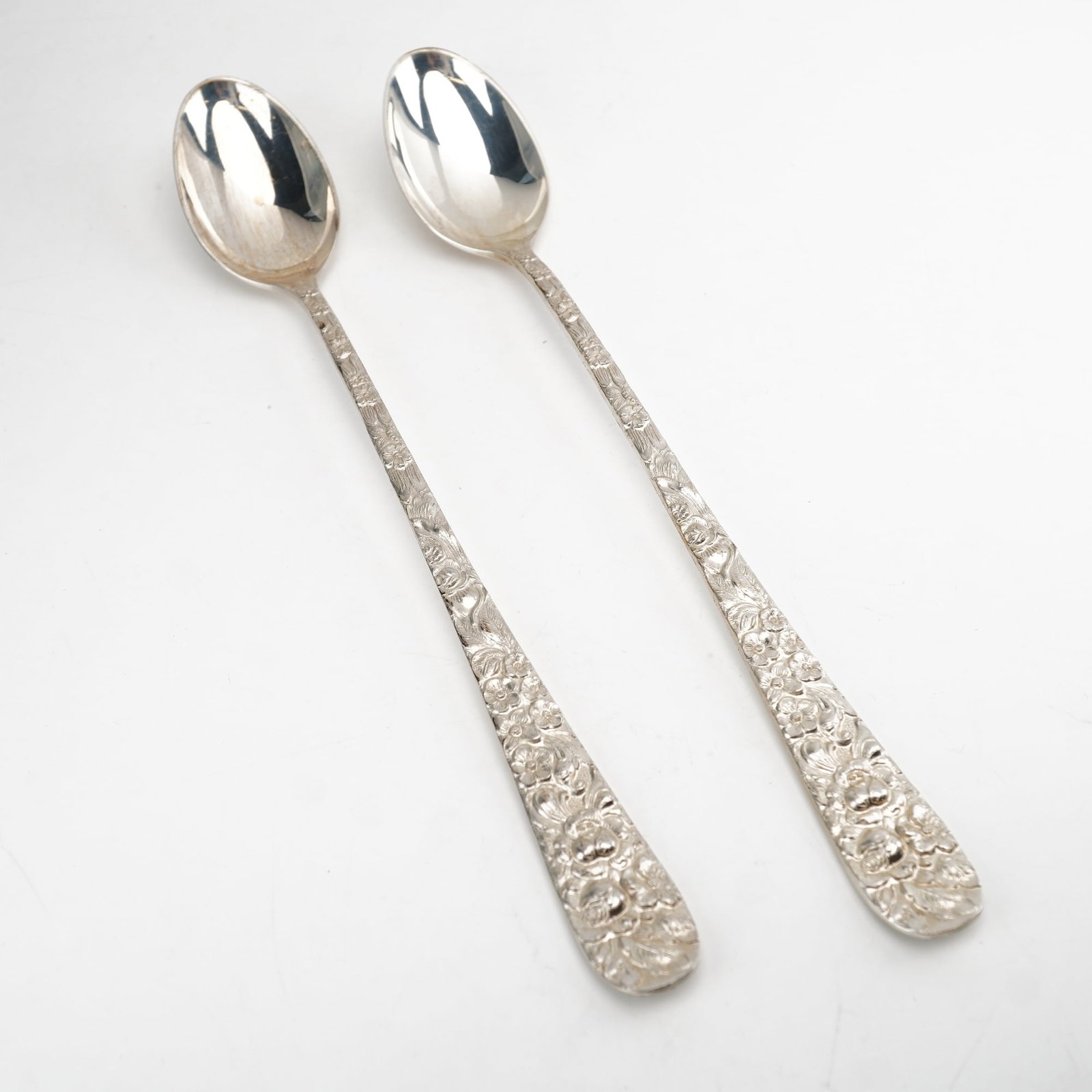 2pc Kirk Stieff Sterling Silver Iced Tea Spoons, Stieff Rose: Elegant pair of iced tea spoons in the classic "Stieff Rose" pattern by Kirk Stieff, originally introduced in 1892. Each spoon features a finely detailed sterling silver handle adorned with ornate flo