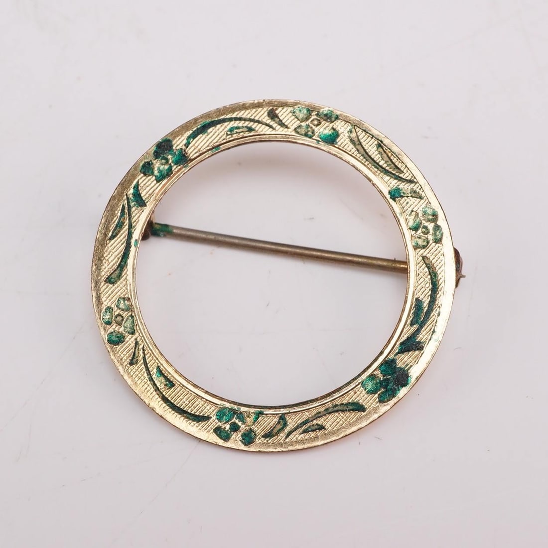 Winard 12K Gold Filled Engraved Floral Circle Brooch: This mid-20th-century circle brooch was manufactured by Winard. The item is constructed from 12 karat gold-filled metal and features a decorative face with an engraved floral and foliate design, depic