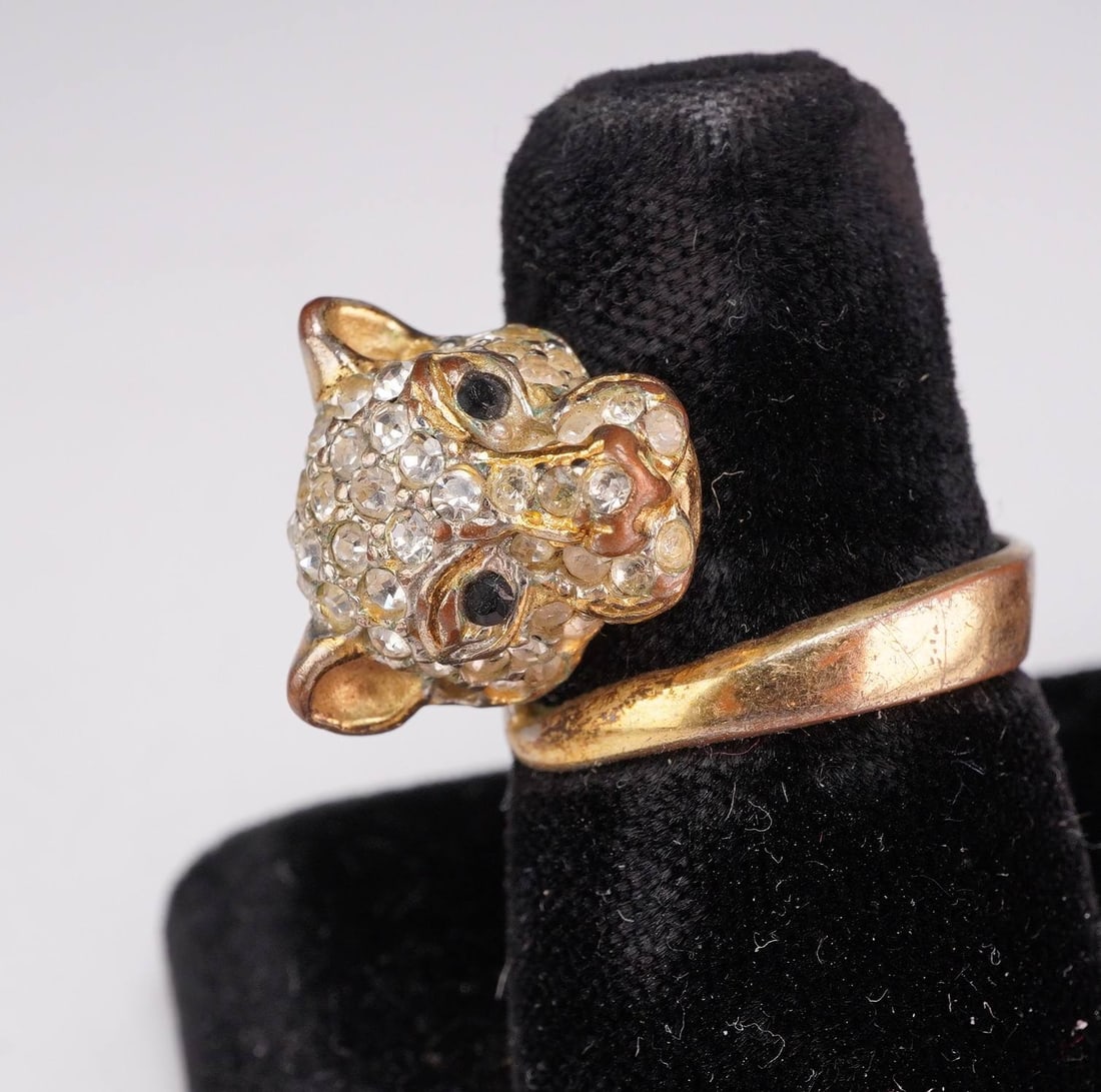 Vintage Gold-Tone Pave Rhinestone Panther Bypass Ring: This vintage figural costume jewelry ring features a panther head in a bypass design. The feline head is pave-set with numerous small round-faceted clear rhinestones, accented by two black stones repr