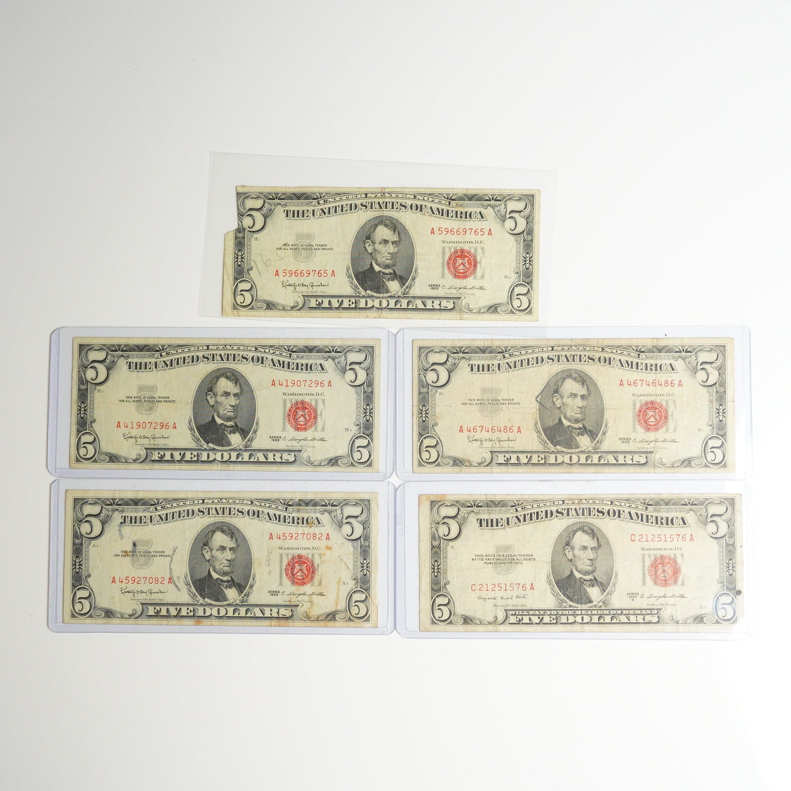 Five 1953 B and 1963 US Five Dollars Red Seal Notes: This collection consists of five US Five Dollar ($5) red seal United States Notes, also known as Legal Tender Notes. The group includes four Series 1963 notes and one Series 1953 B note. Each note fea