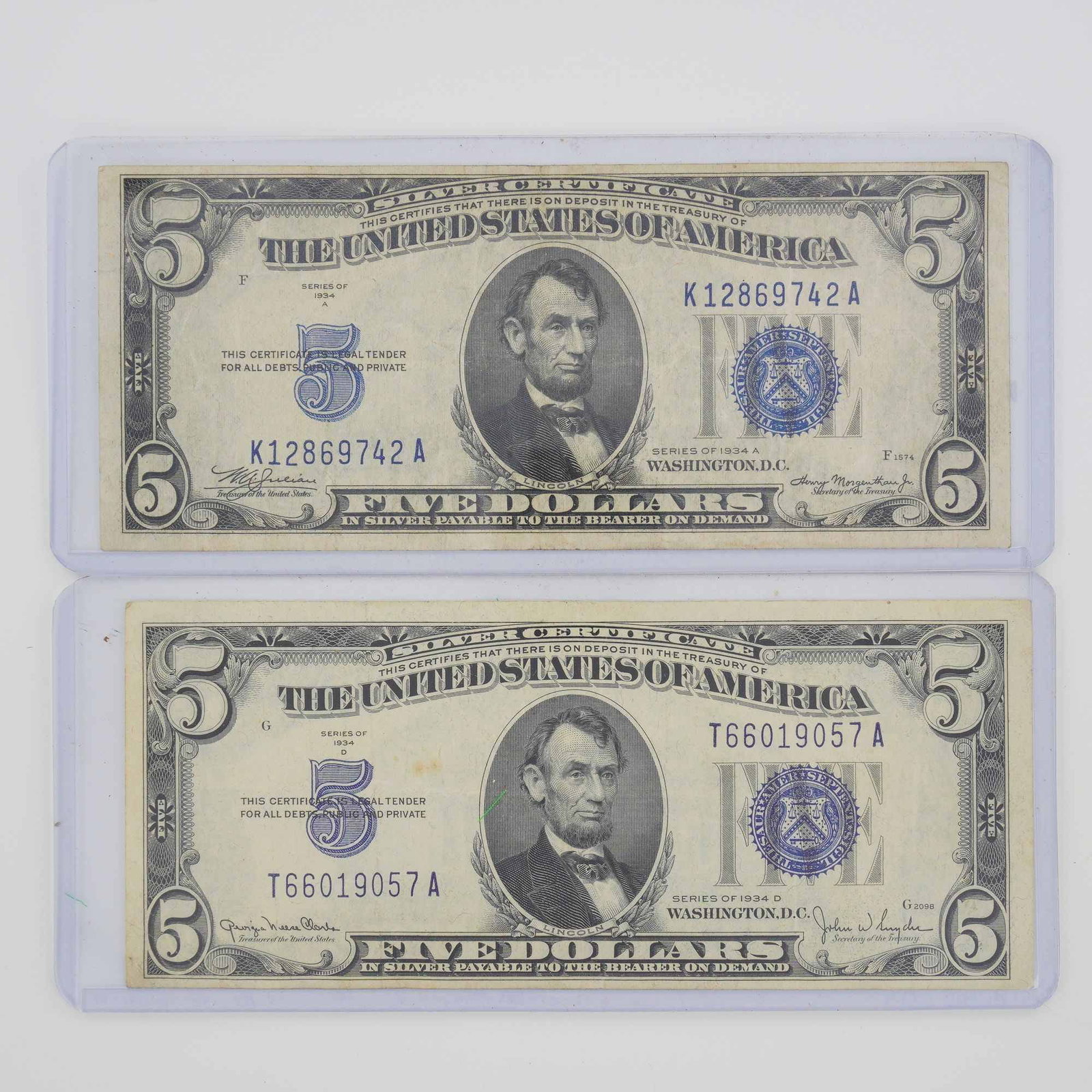 Pair of 1934-A & D US Five Dollars Silver Certificates, Blue Seal Bills: This lot consists of two US $5 Silver Certificates. The top note is a Series of 1934 A, bearing serial number K12869742 A and the printed signatures of Treasurer W. A. Julian and Secretary of the Trea