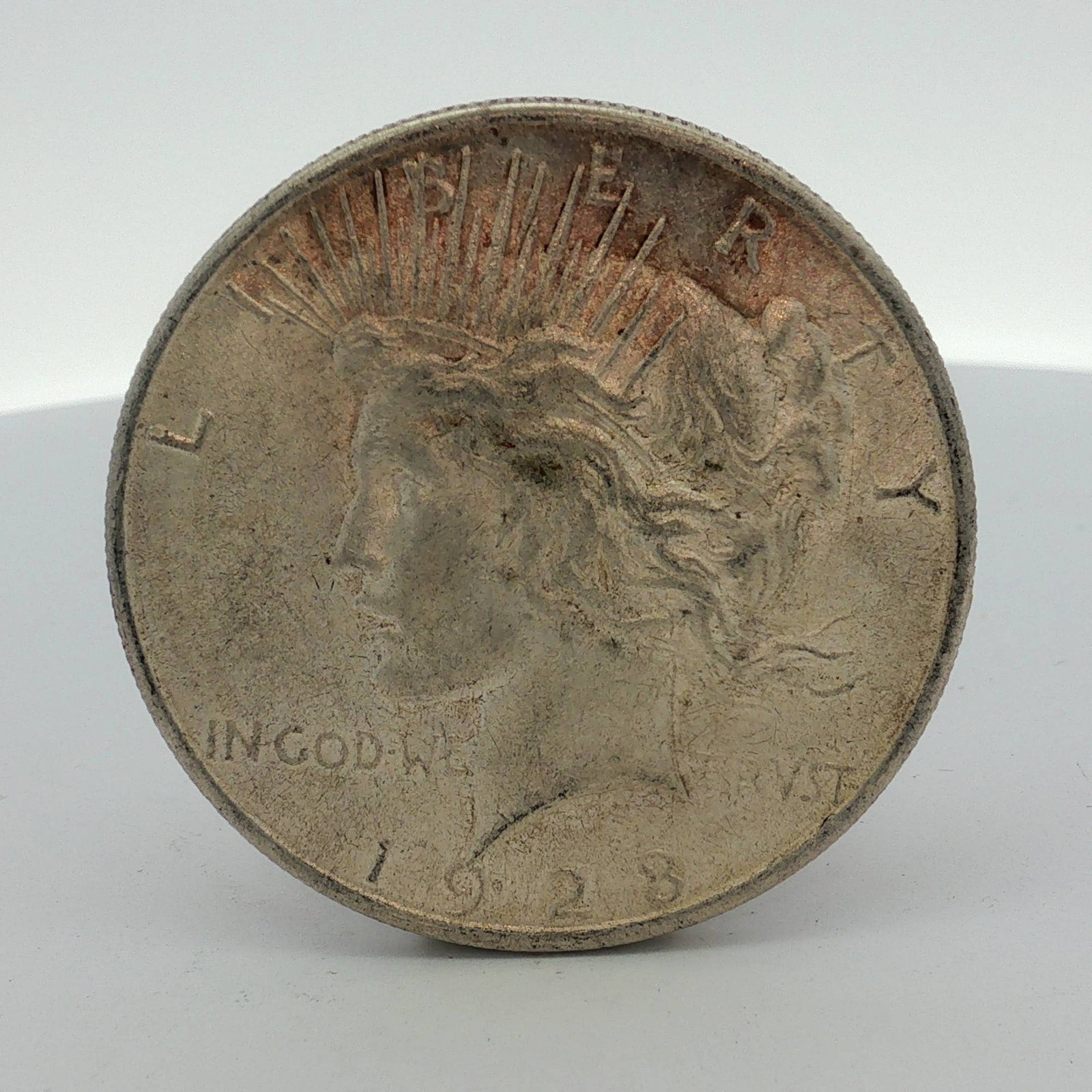 1923-S US One Dollar Silver Peace Dollar Coin, Circulated: One US Peace silver dollar dated 1923, struck at the Philadelphia mint. This coin is composed of 90% silver and 10% copper. It features the standard Peace dollar obverse and reverse design types. The