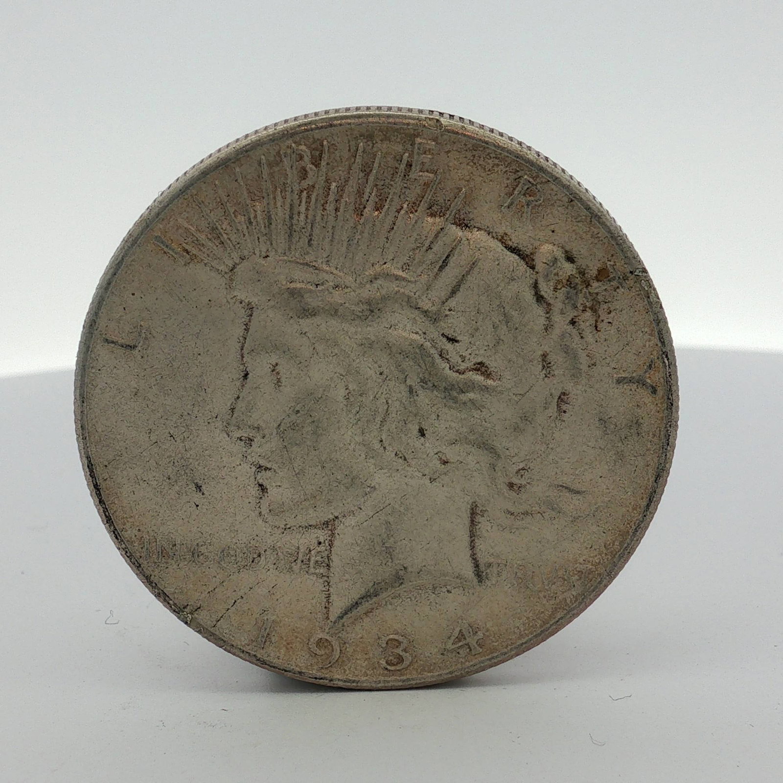 1934-S US Peace Silver Dollar: This is a 1934 US Peace silver dollar. The coin is struck in .900 fine silver. The obverse displays the Peace dollar obverse design with the year 1934 and the motto IN GOD WE TRVST. The reverse