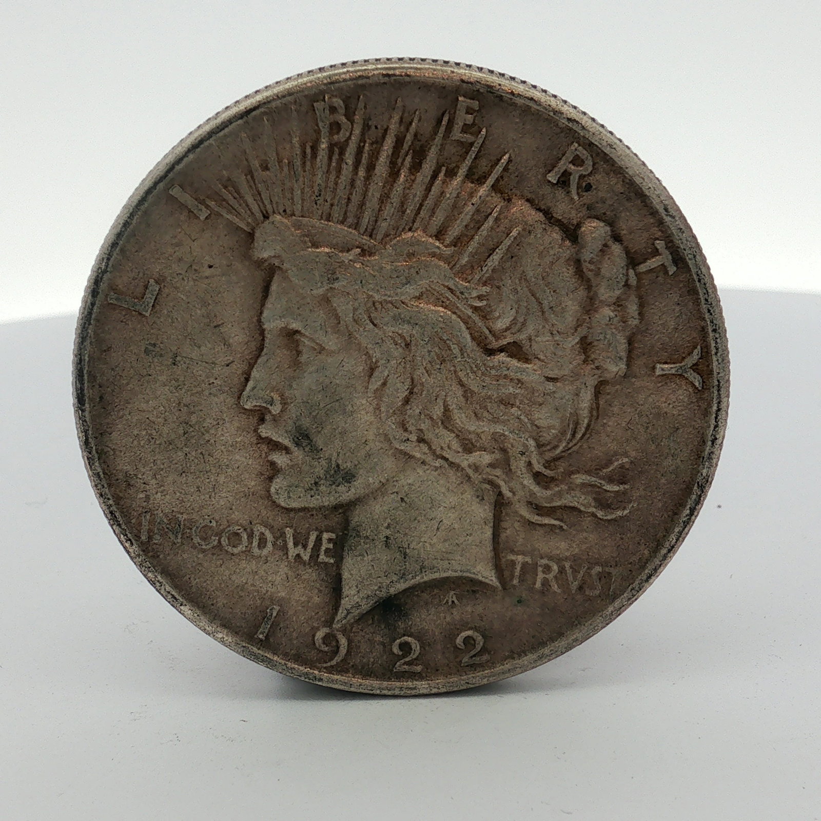 US 1922 Peace Silver Dollar: A US 1922 Peace silver dollar minted in Philadelphia. The coin is struck in 90% silver and 10% copper with a reeded edge. The obverse features the Liberty head design by Anthony de Francisci, with