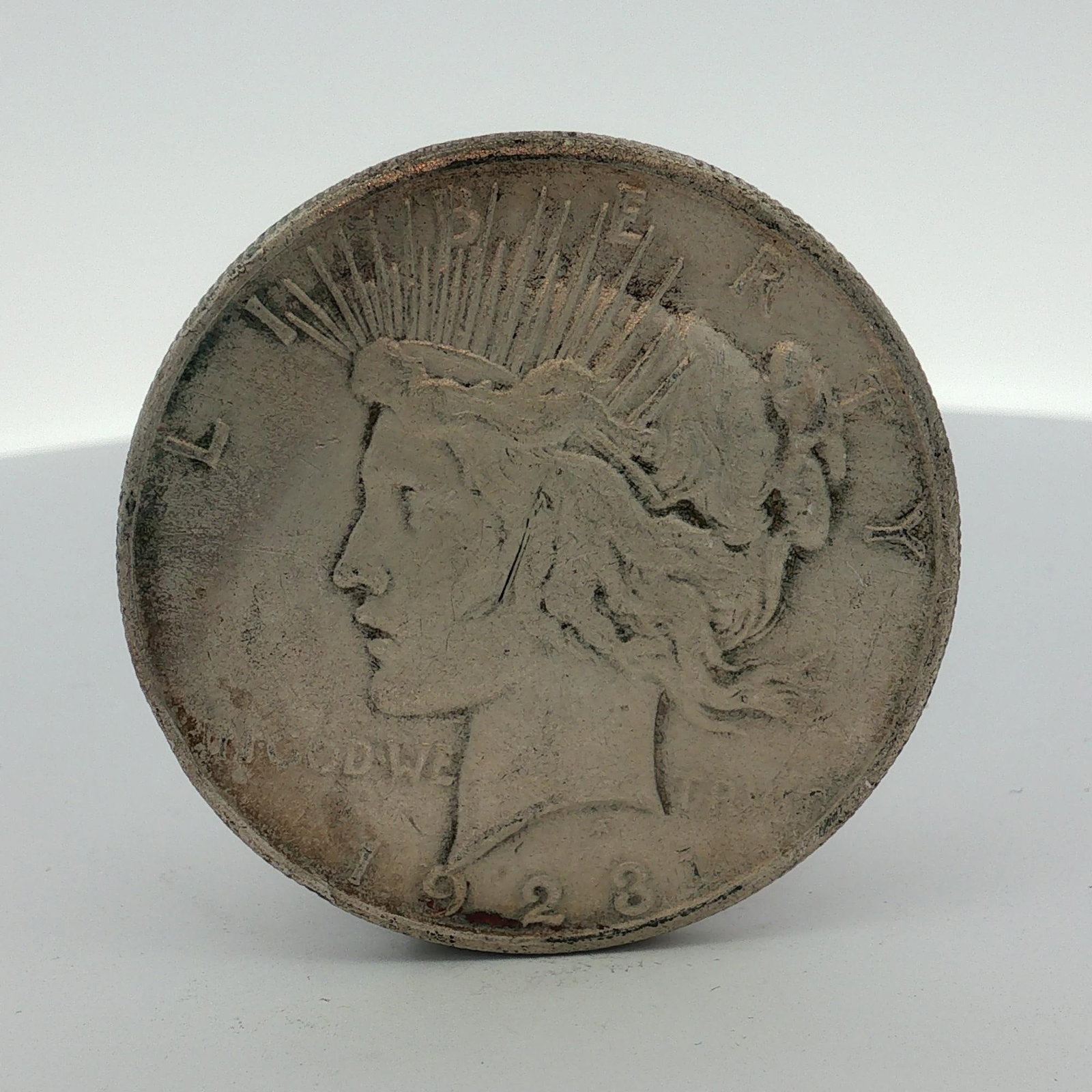 US 1923 Peace Silver Dollar: A 1923 US Peace silver dollar struck in 90% silver and 10% copper. The obverse features the Peace dollar design with the inscriptions LIBERTY, IN GOD WE TRVST, and the date 1923. The reverse features