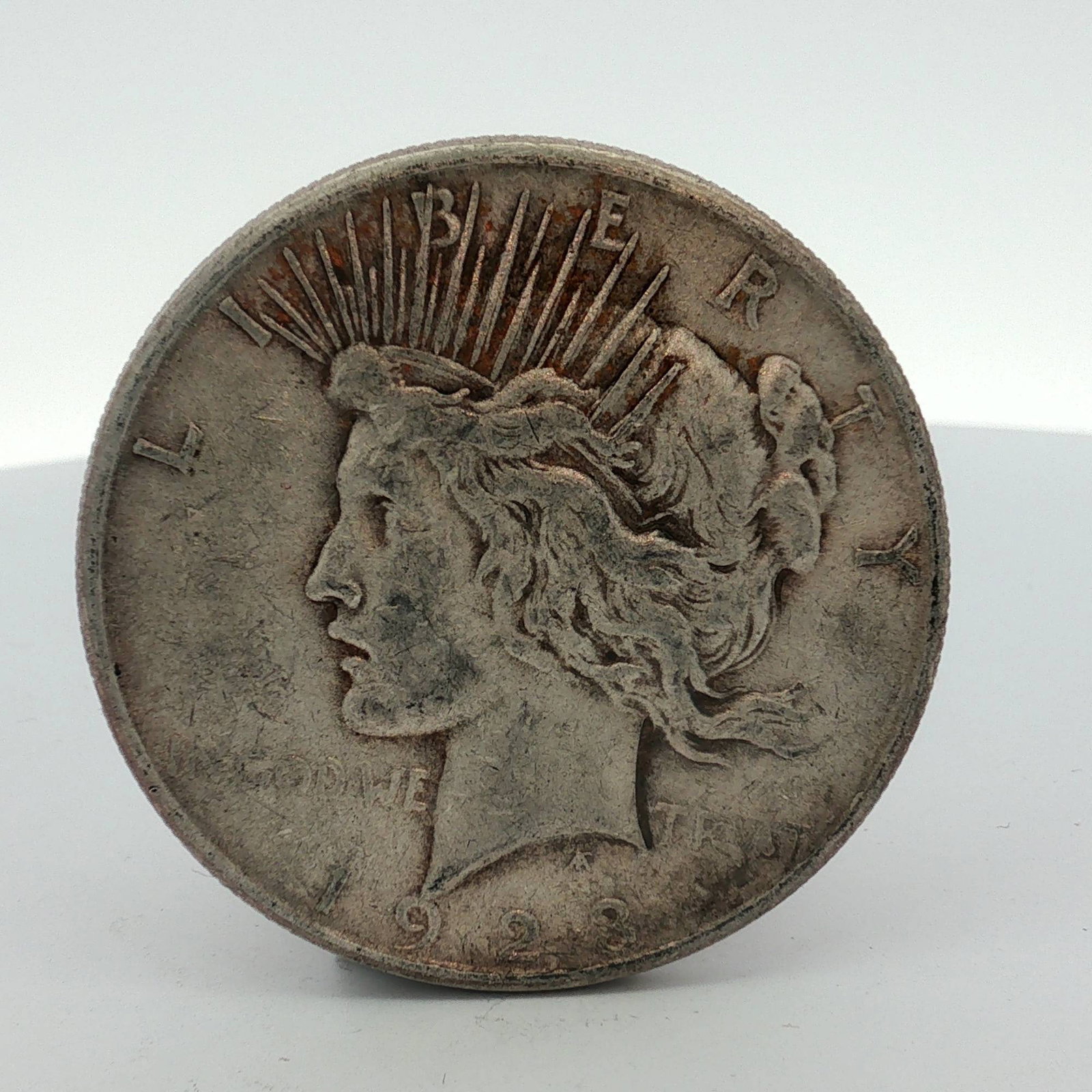 US 1923-S Peace Silver Dollar: This US 1923-S Peace silver dollar is composed of 90% silver and 10% copper. It features the standard obverse and reverse designs for the series by Anthony de Francisci. The "S" mint mark is visible