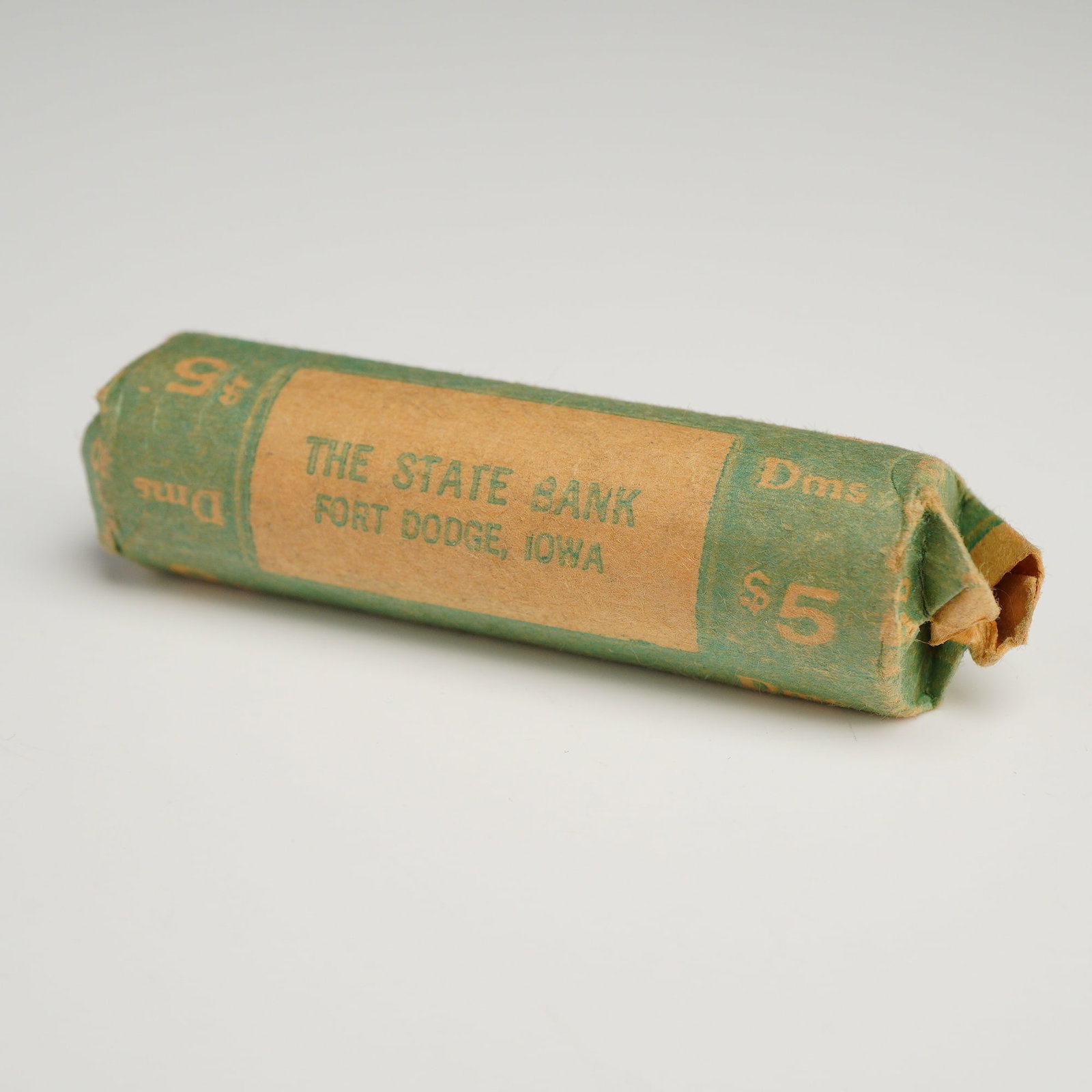 1 Roll of US $5.00 Bank Roll of 50 Mixed Date Dimes: This item is an unopened bank-wrapped roll (OBW) of US dimes, identified as a mixed date roll of 50 coins with a total face value of $5.00. The coins are contained within a green and tan paper wrapper