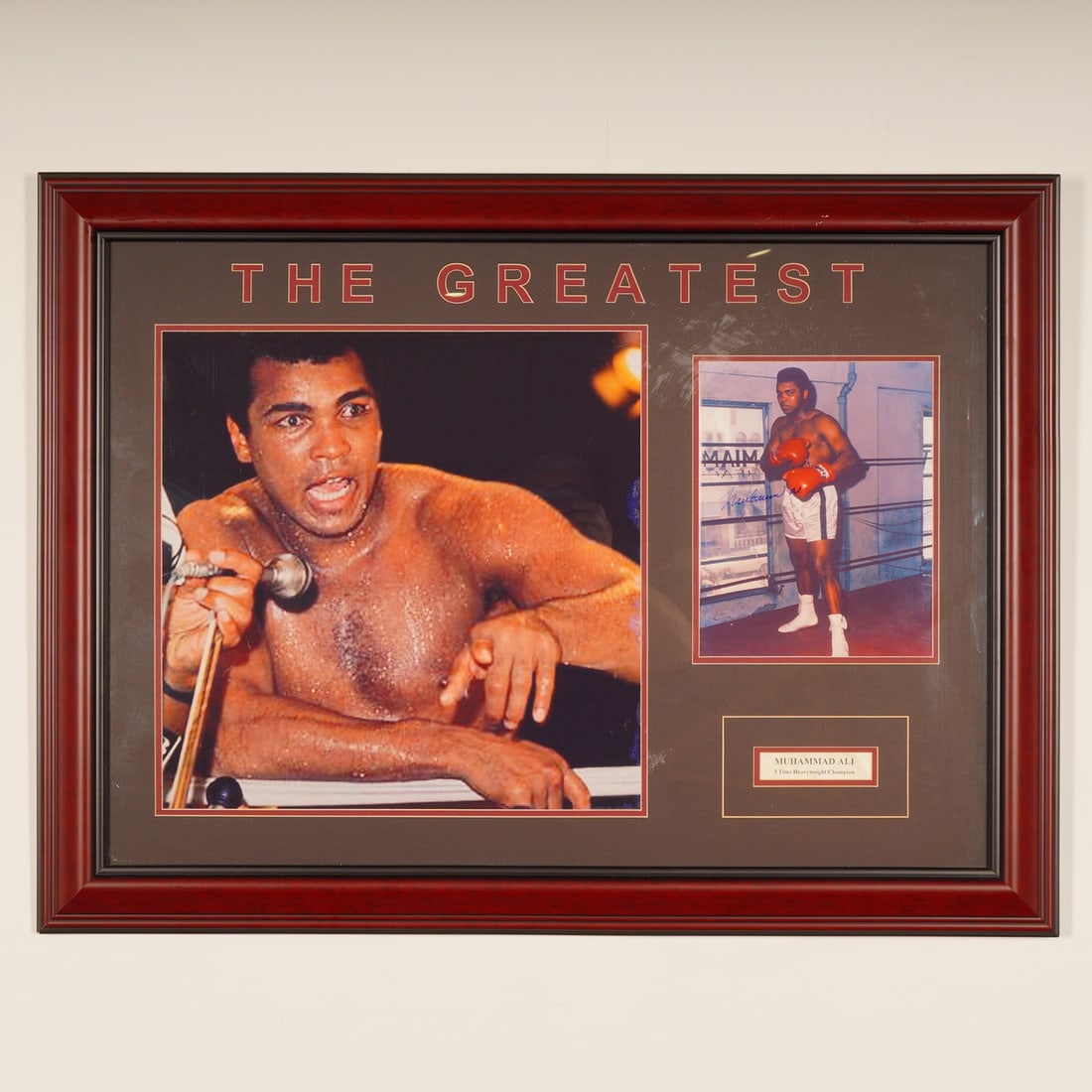 Muhammad Ali "The Greatest" Framed Autographed Photograph: A framed commemorative display piece featuring two color photographs of boxer Muhammad Ali (Cassius Clay.) The display is set within dark brown matting and a reddish-brown wood frame, titled "THE
