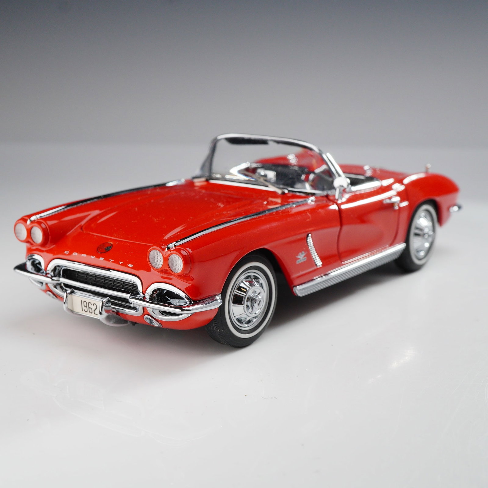 Danbury Mint 1962 Chevrolet Corvette Convertible 1:24 Scale Model: This 1:24 scale die-cast model is a replica of a 1962 Chevrolet Corvette from the Danbury Mint Classic Cars Collection. The vehicle is finished in Roman Red with chrome-effect bumpers, trim, and