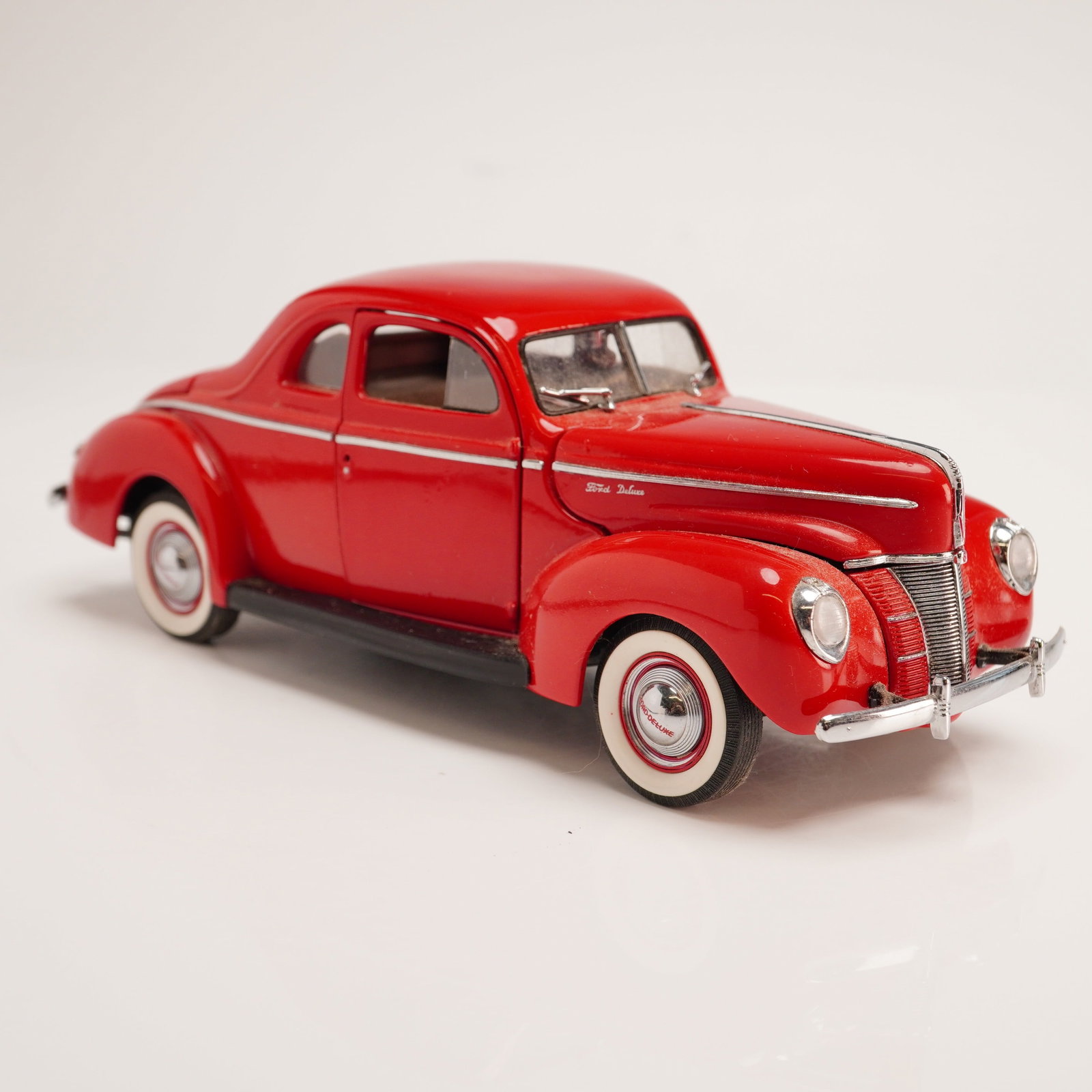 The Danbury Mint Classic Model Car, 1940 Ford Deluxe Coupe: This item is a 1:24 scale precision die-cast replica of a 1940 Ford Deluxe Coupe from The Danbury Mint Classic Cars Collection. The model is constructed from die-cast metal with plastic components