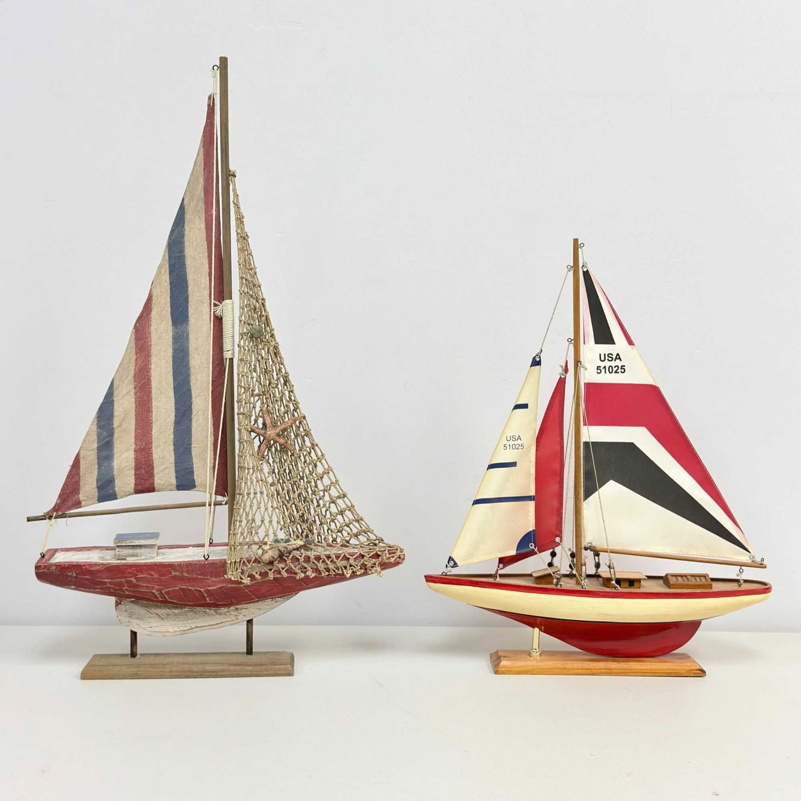 Two Wooden Handcrafted Sailboat Models: This lot features two handcrafted wooden decorative sailboat models, including a modern-style USA Sailer and a rustic-themed model. The first sailboat is a contemporary decorative model resembling