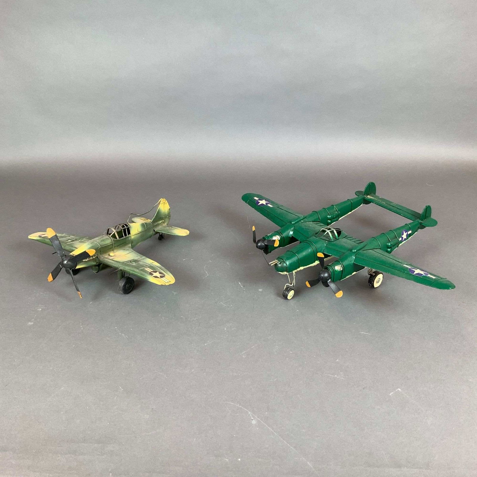 2pc United States Army Air Forces Fighter Aircraft Models: A pair of United States Army Air Forces aircraft models, comprising a Lockheed P-38 Lightning style twin-boom fighter and a Curtiss P-40 Warhawk style single-engine fighter. Both models are constructe
