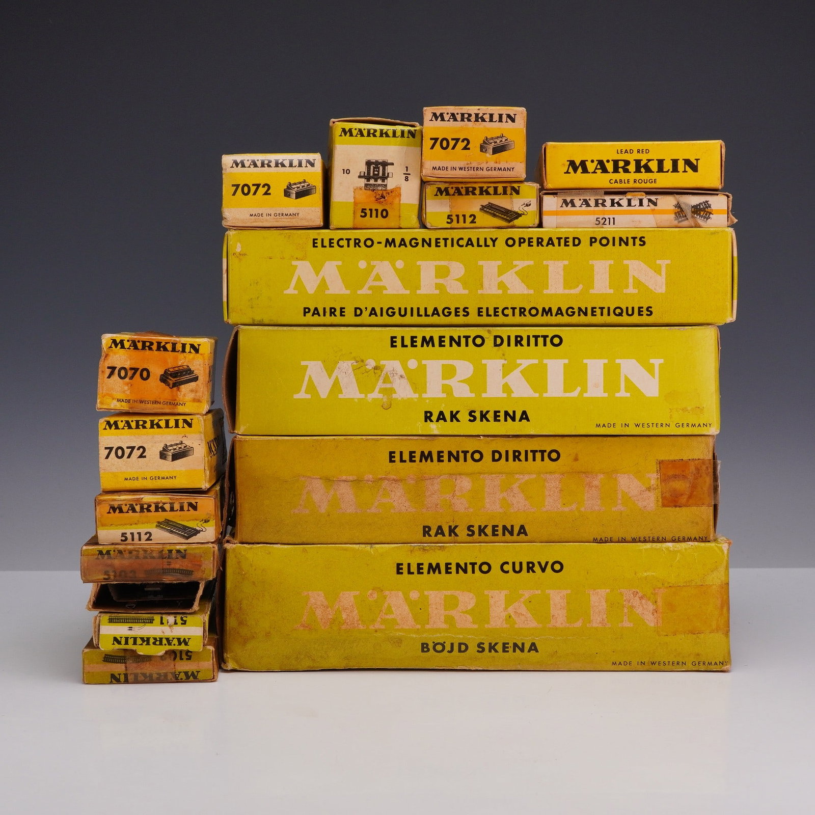 16pc Marklin Assorted Train Tracks and Model Railroad Accessories in Original Boxes: This lot features 16 Marklin assorted train tracks and accessories manufactured in Germany and Western Germany. The collection includes various H0 scale model railroad components, primarily M-track se