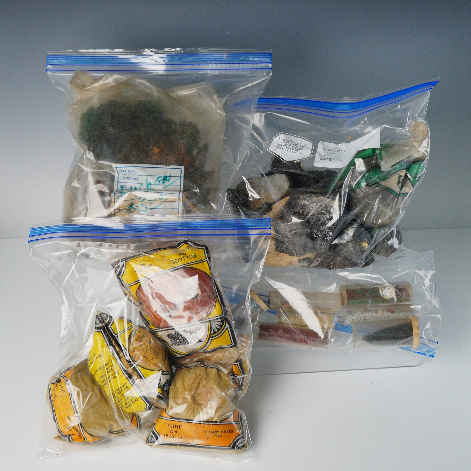 Lot of Woodland Scenics Model Railroad Landscape Materials: A collection of model railroad or diorama scenery materials, primarily manufactured by Woodland Scenics. The lot of train landscape items is organized into four clear plastic ziploc bags containing