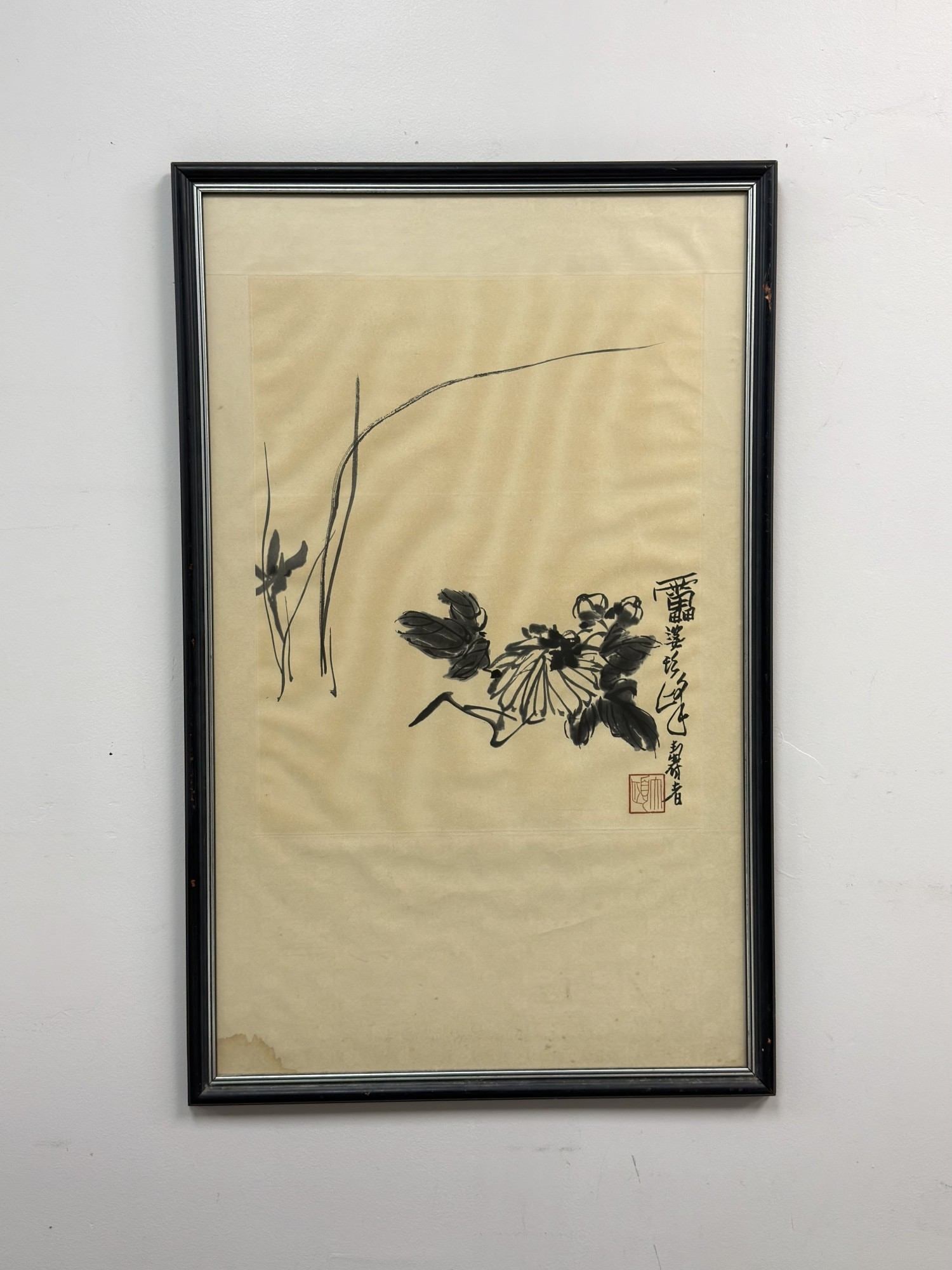 Chinese Ink Wash Painting of Chrysanthemum Attributed to Pan Tianshou: This 20th-century framed Chinese ink wash painting is attributed to the artist Xu Linlu (1897-1971). The work depicts a chrysanthemum blossom with dark, expressive leaves and slender blades of grass i