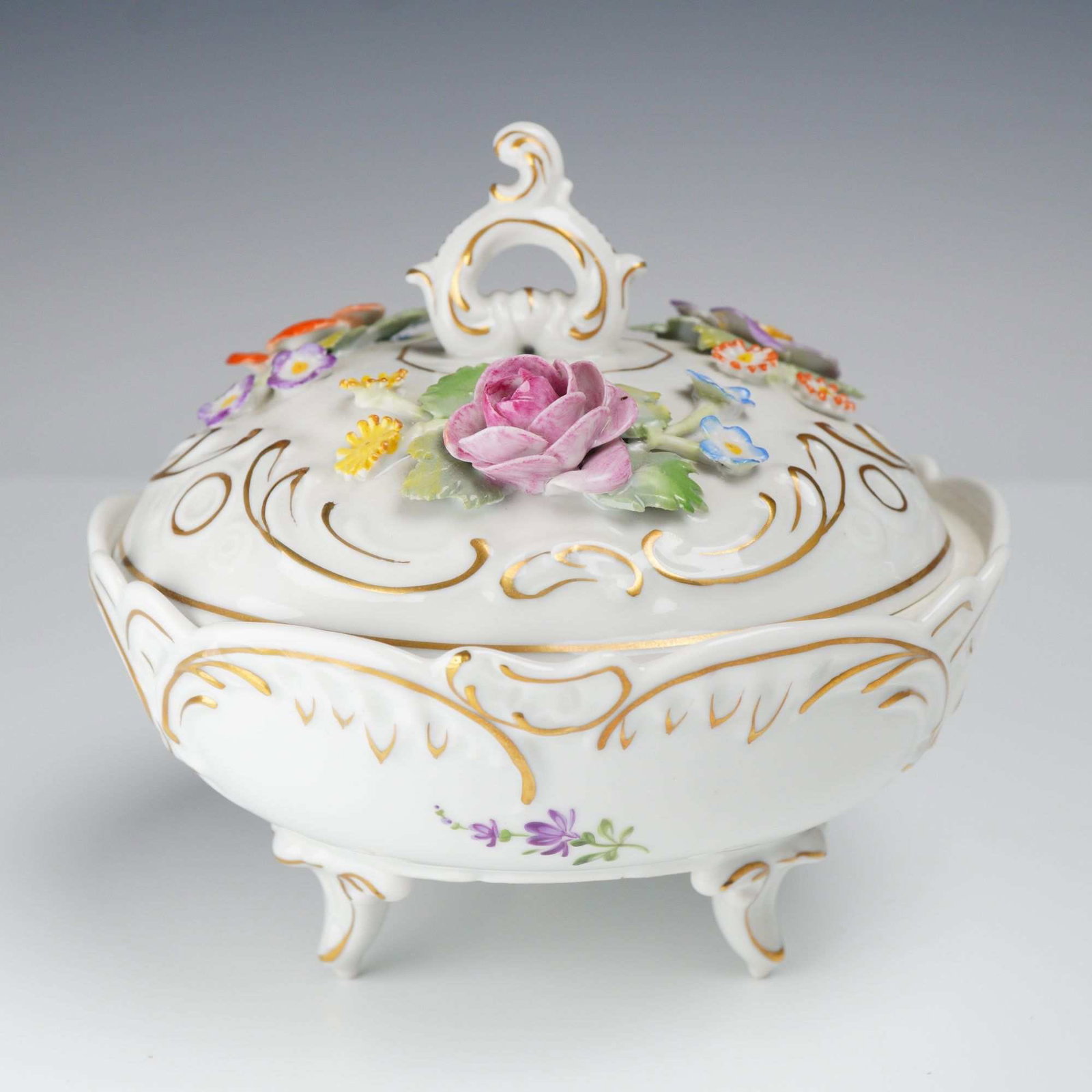 Vintage Von Schierholz Dresden German Porcelain Floral and Gilded Footed Bowl with Lid: A vintage Von Schierholz German porcelain footed bowl with a lid, decorated in the Dresden style with encrusted floral motifs and gilded accents. The circular bowl is supported by three scrolled feet.