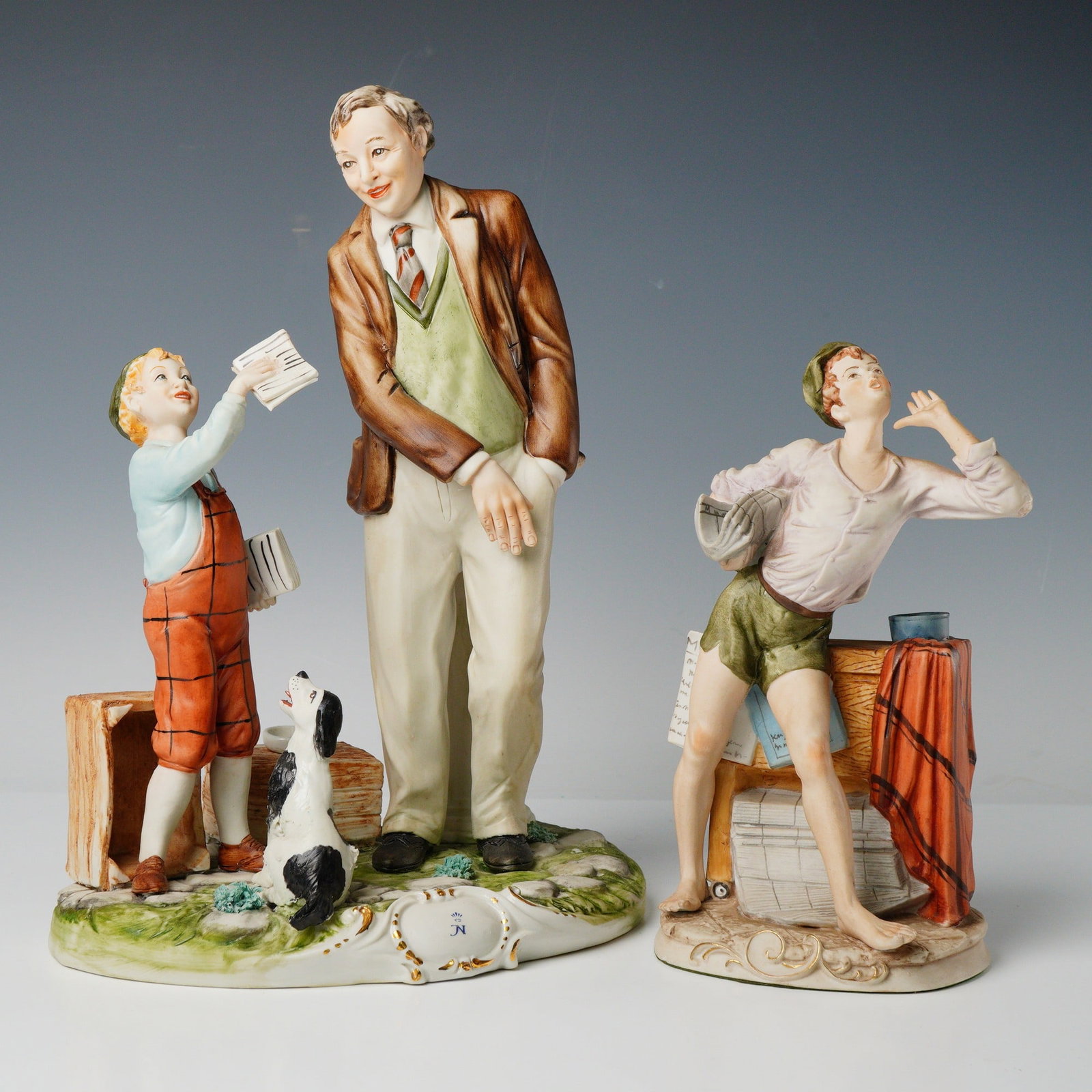 2 Italian Porcelain Figurines Signed Meneghitelli & Benni: A pair of polychrome glazed porcelain genre sculptures, likely 20th-century Italian production. The first and largest piece depicts a standing adult man in a brown jacket and light trousers,