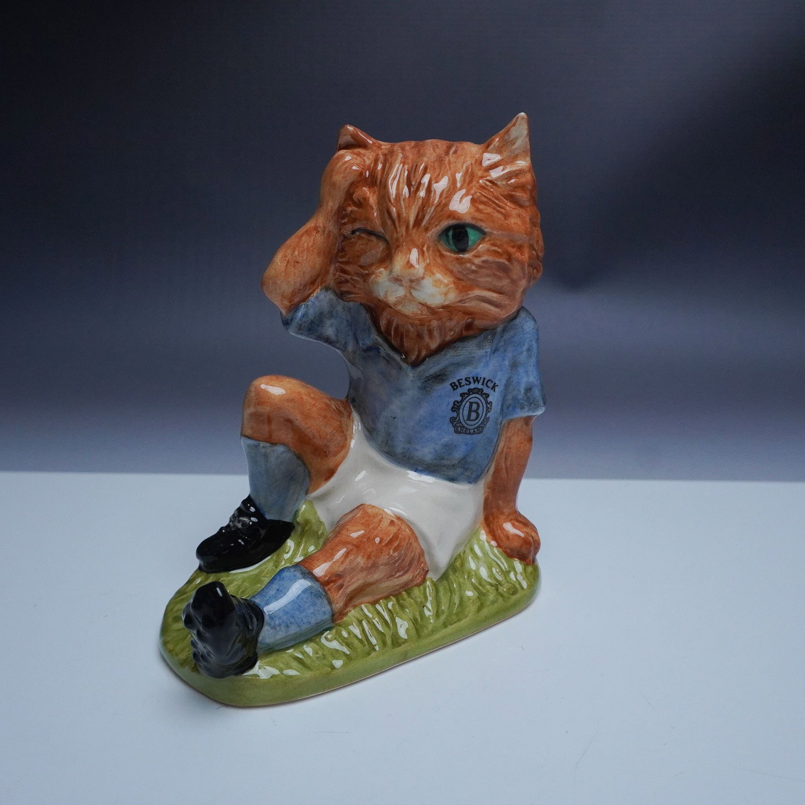John Beswick Mee-Ouch Footballing Felines Figurine, Ltd. Ed.: From the Footballing Felines collection, this charming Mee-Ouch figurine (FF2) depicts a ginger cat in a blue football jersey, playfully holding its head in misfortune. A 1998 limited edition of