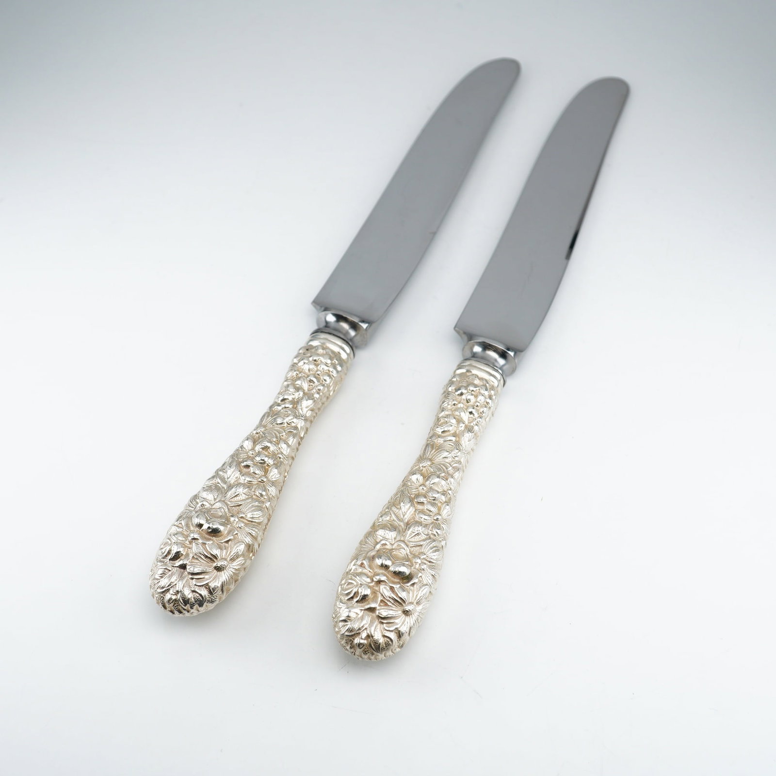 2pc Kirk Stieff Sterling Silver and Stainless-Steel Dinner Knives, Stieff Rose: Two dinner knives in the traditional Stieff Rose design by Kirk Stieff, originally introduced in 1892. Each knife features a sterling silver handle adorned with finely detailed floral repousse work