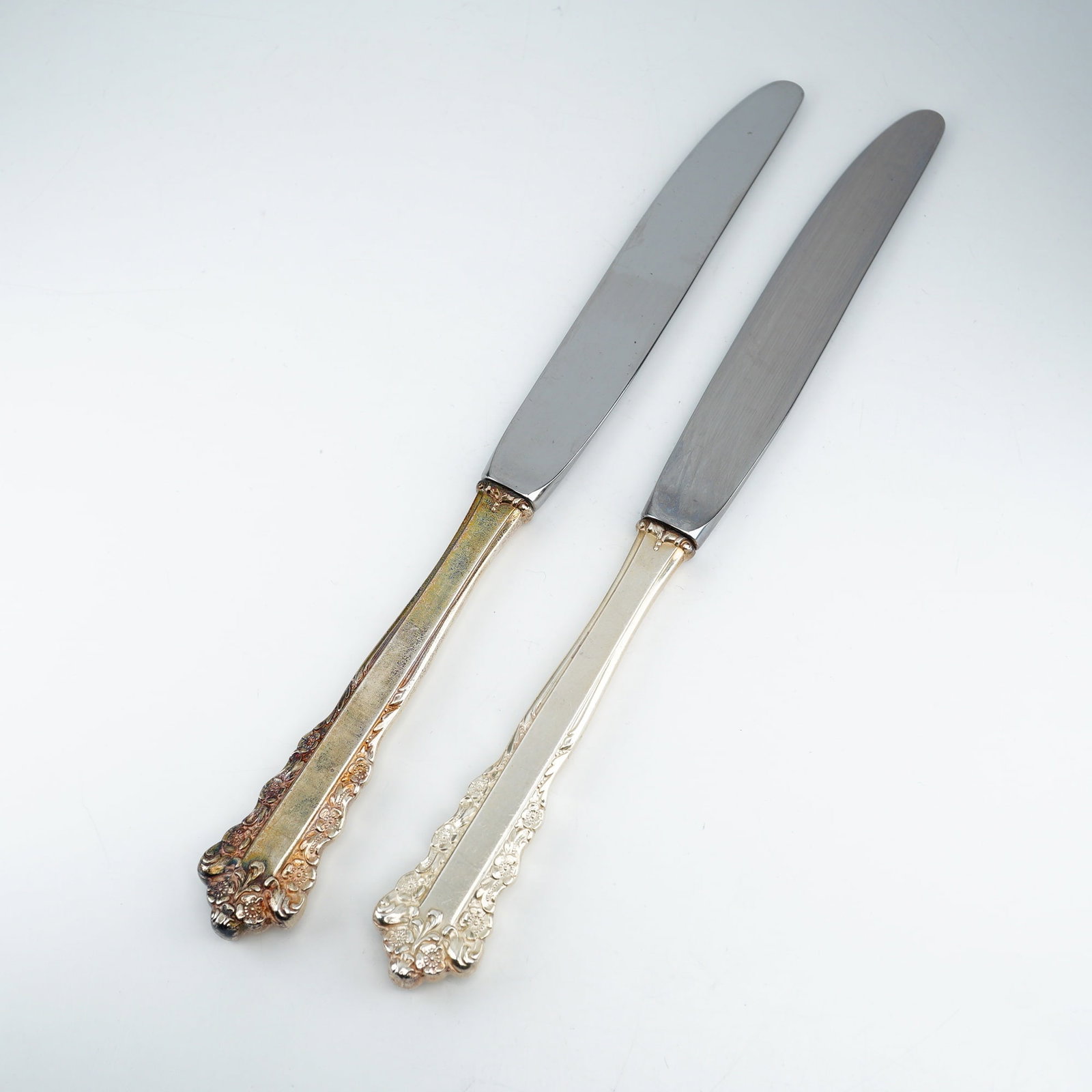 2pc Lunt Sterling Silver and Stainless Steel Dinner Spreaders, Belle Meade: Produced by Lunt Silversmiths between 1967 and 1997, these elegant spreaders feature ornate Rococo-inspired detailing with relief-molded floral clusters and scrolling along the handle edges and