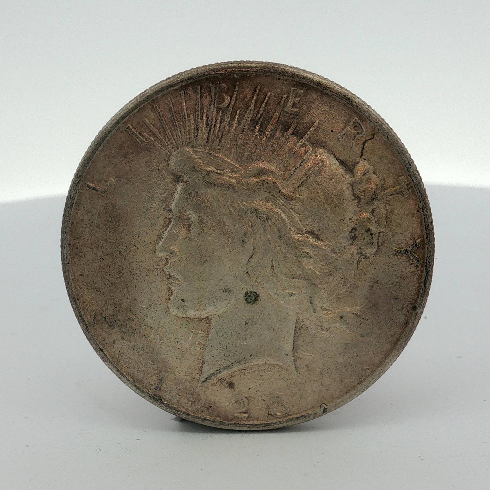 1923 US Peace Silver Dollar: This 1923 US Peace silver dollar is a Philadelphia Mint issue, characterized by the absence of a mint mark. It is composed of 90 percent silver and 10 percent copper. The obverse features the standard
